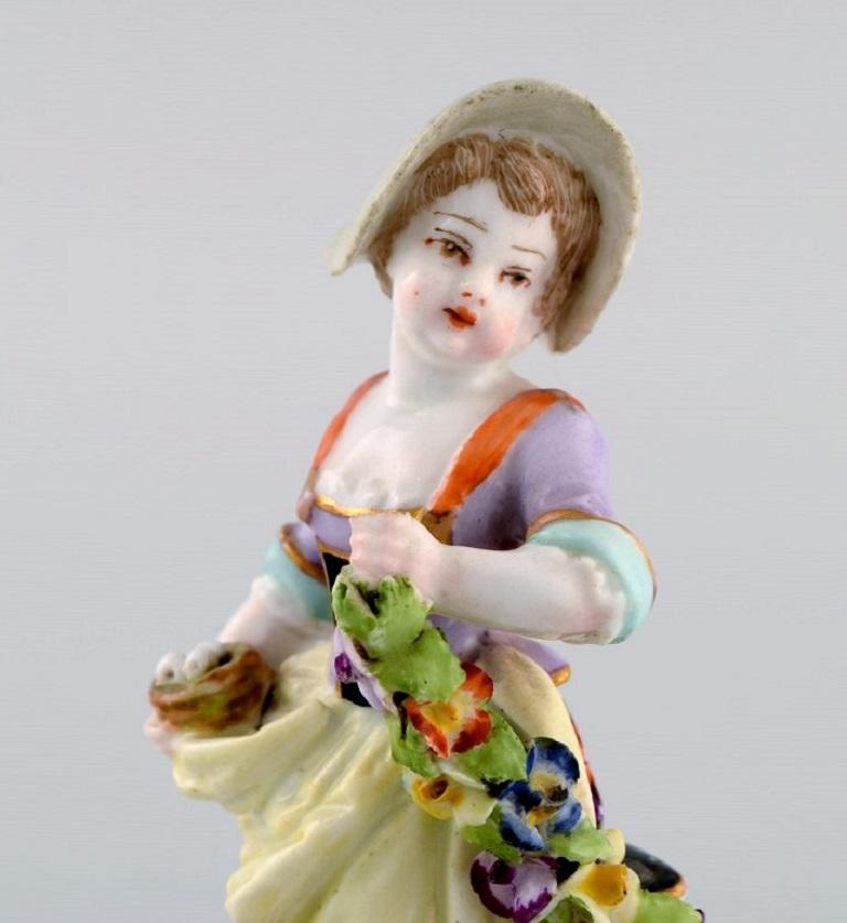 Augustus Rex, Germany. Antique hand-painted porcelain figure. 
Girl with flowers and fruit. 19th century.
Measures: 11 x 5.5 cm.
In good condition. Minimal chips.
Signed.