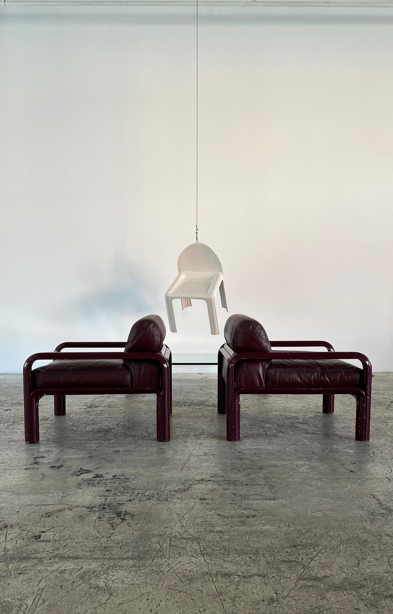 This arm chair was designed by Gae Aulenti for Knoll International in 1974 as part of the Aulenti Collection with matching sofas and coffee tables. This chair is made of a maroon enameled channel metal body and the original maroon leather