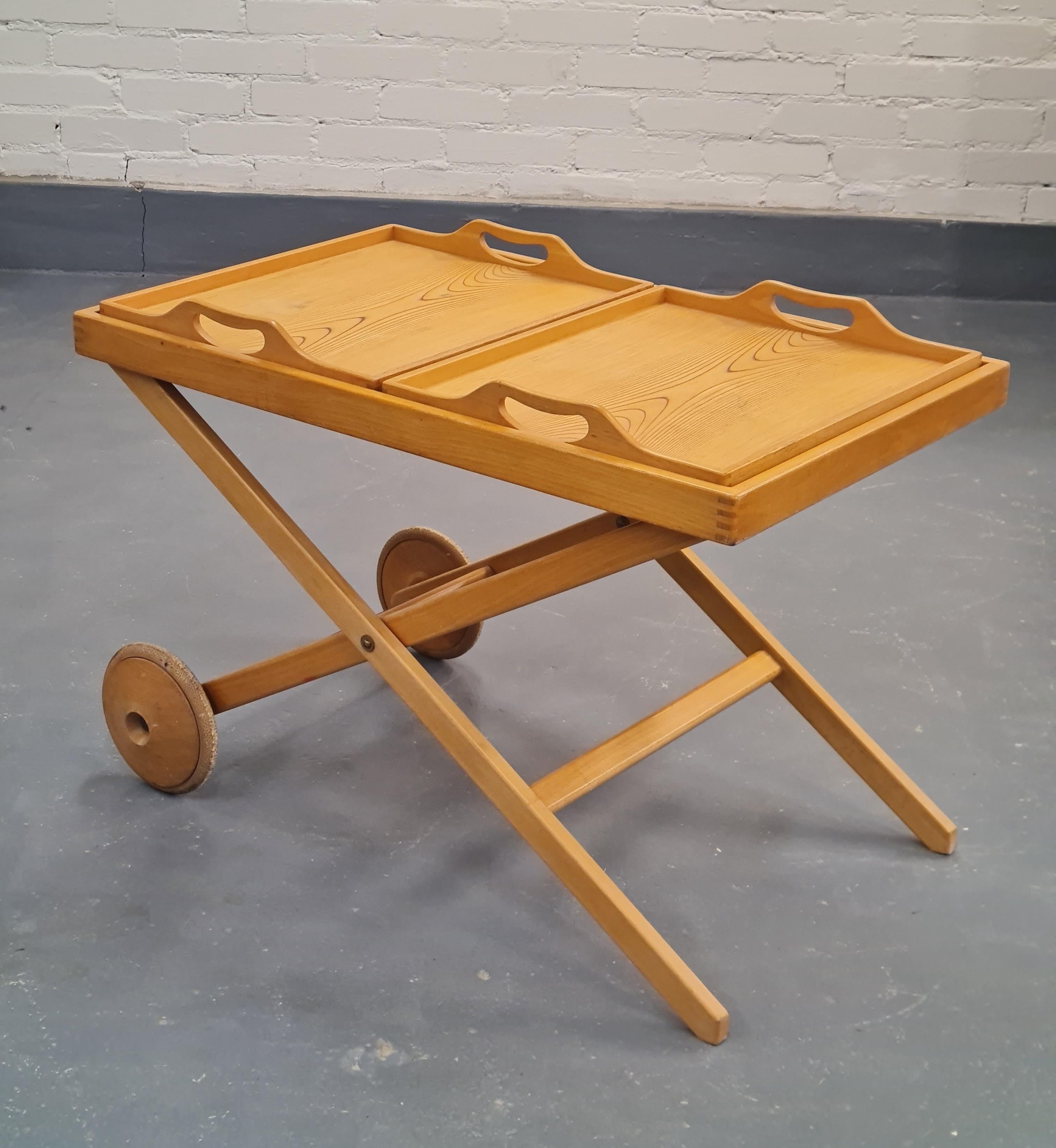 A rare and elegant wooden trolley in lacquered beech and rhythmic birch, manufactured by Asko in Finland for only two years from 1950-1951. The design is a team effort between the world renowned Tapio Wirkkala and Aulis Leinonen, an interior