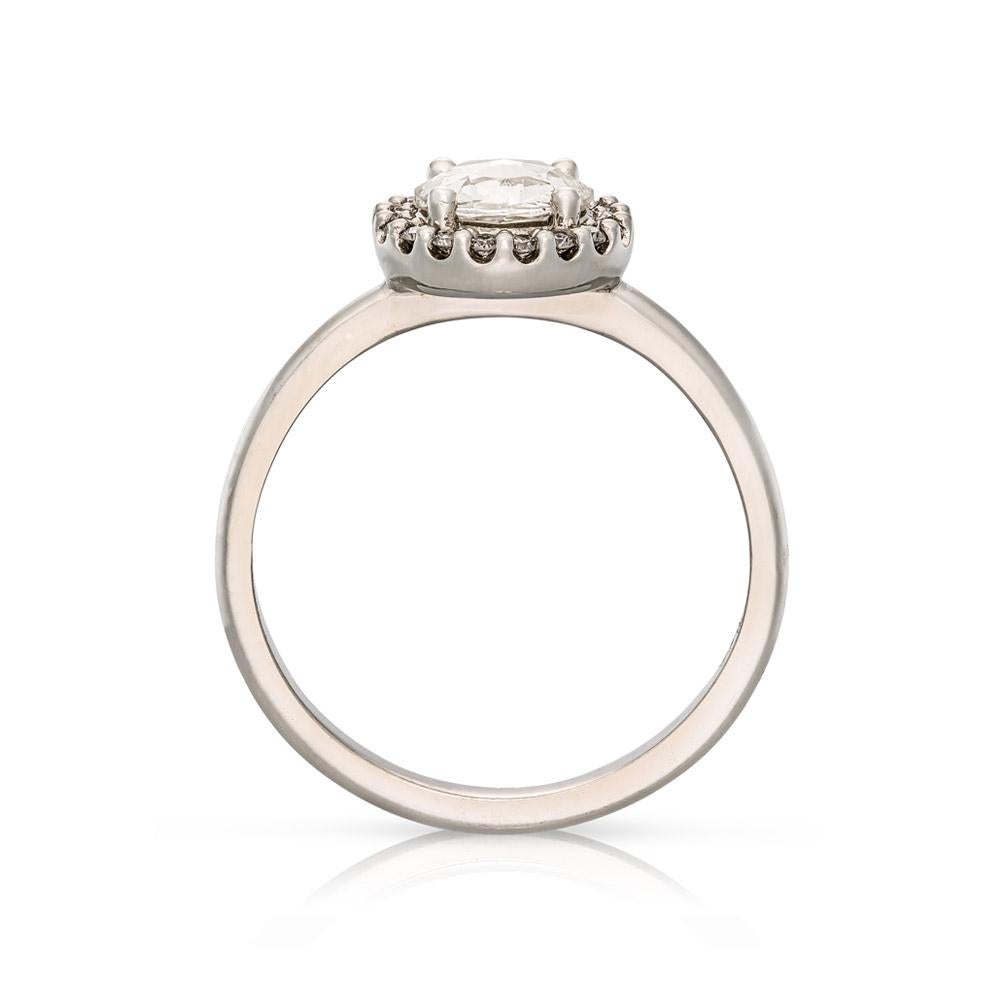 The Aura Engagement Ring features a rose cut diamond at its centre surrounded by a diamond halo. This unusual cut is unique as the facets appear on the top of the stone, rather than beneath, so as to capture the light. The halo of brilliant round