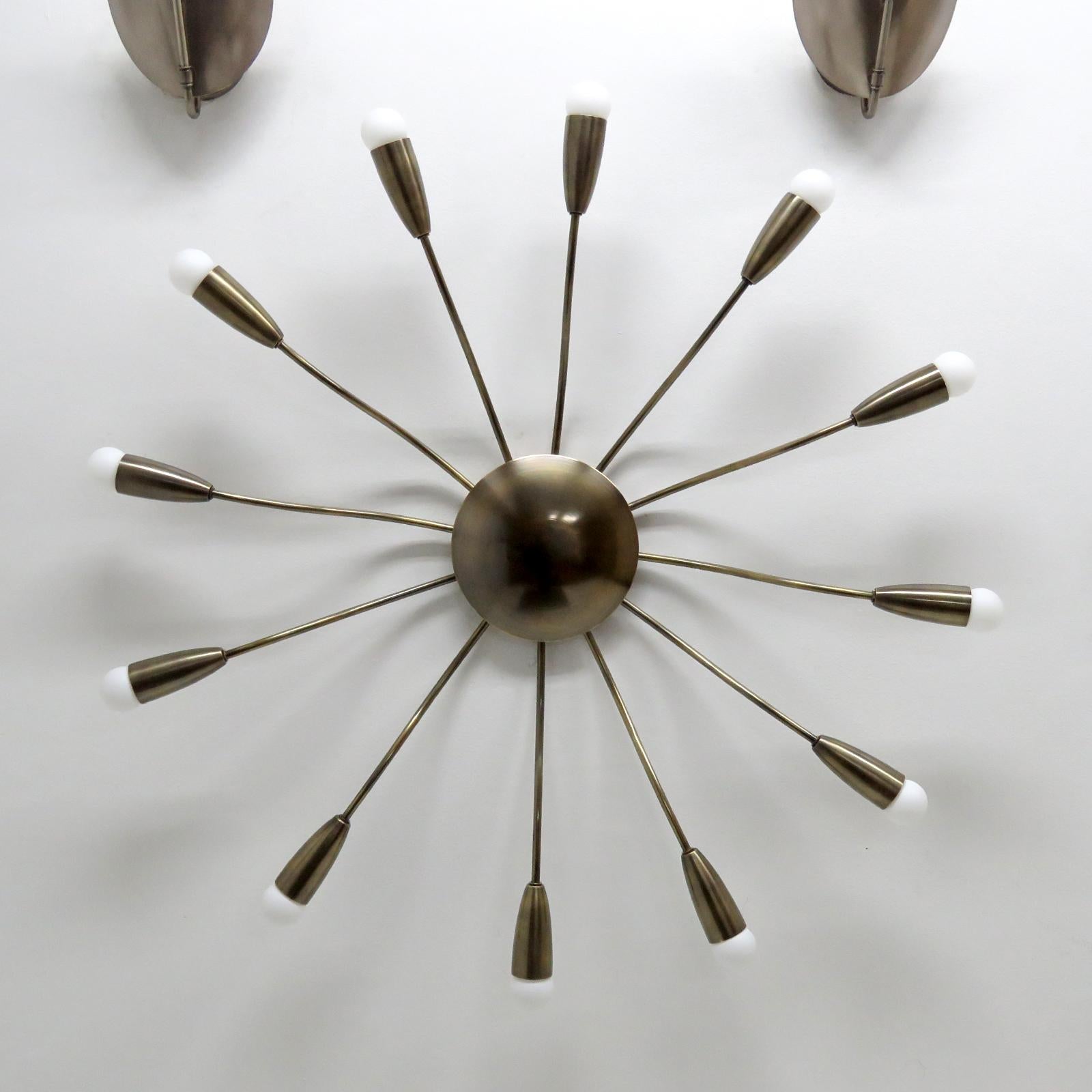 Élégante applique ou plafonnier Aura-38 à douze lumières en laiton vieilli, conçue par Gallery L7, fabriquée et finie à la main à Los Angeles à partir de laiton américain. Douze douilles E12 par luminaire, puissance maximale de 25 watts chacune ou