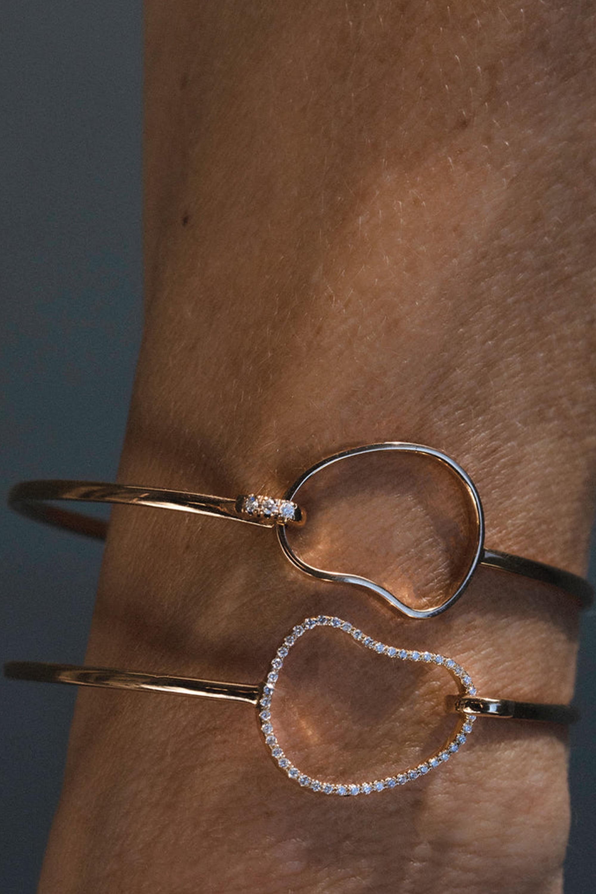 Il bracciale AURA, realizzato in oro rosa 18 carati, combina un'eleganza senza tempo con un tocco di lusso. La sua forma organica, incastonata con 0,25 carati di diamanti pavé, offre un senso di autentica indulgenza pur rimanendo facilmente