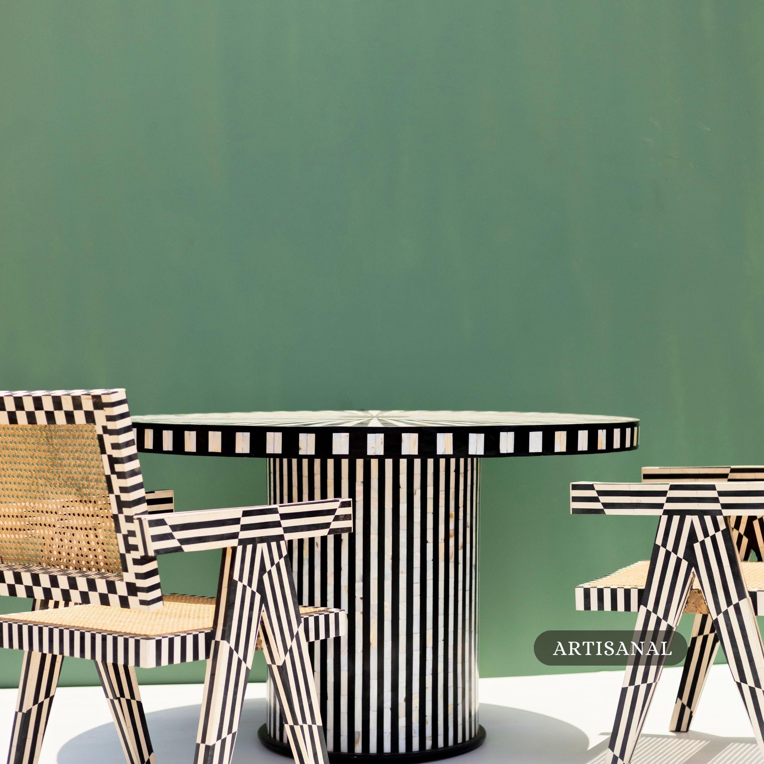 The Aura Dining Table is a striking statement piece that blends timeless craftsmanship with modern design. Handcrafted by skilled artisans, its round surface features a bold sunburst pattern in black and white mother of pearl inlay, radiating