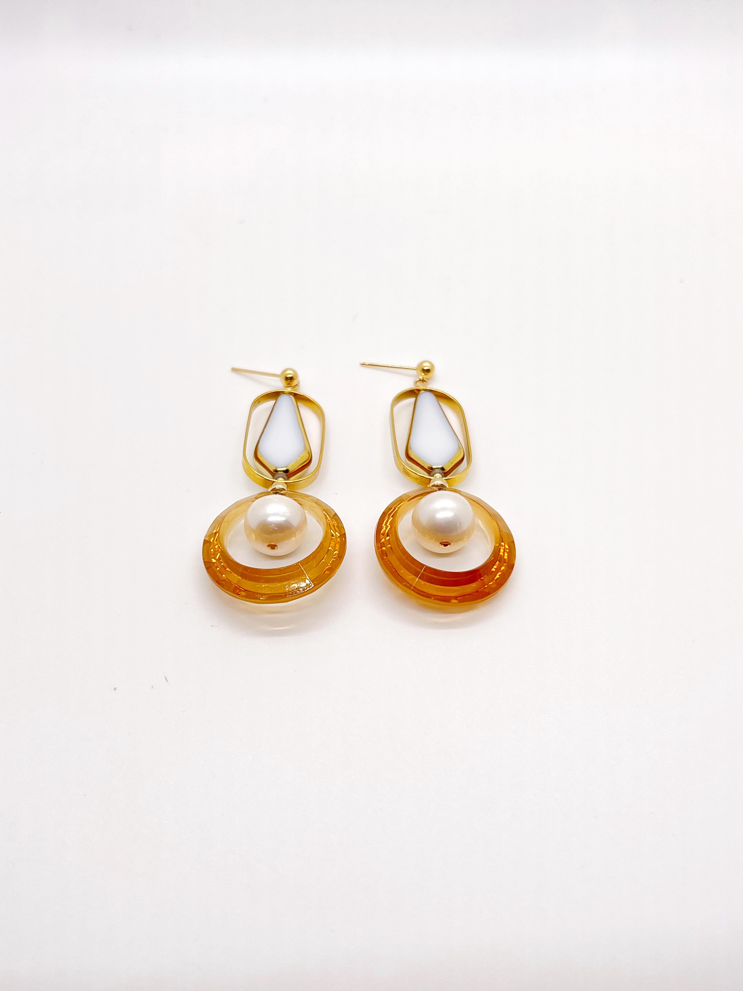 Each earring consist of white arrow vintage German glass beads edged with gold, brass metal plated with 24K gold,  caramel lucite round bead, freshwater pearls, gold-filled findings and ear stud.

The vintage German glass beads were hand pressed