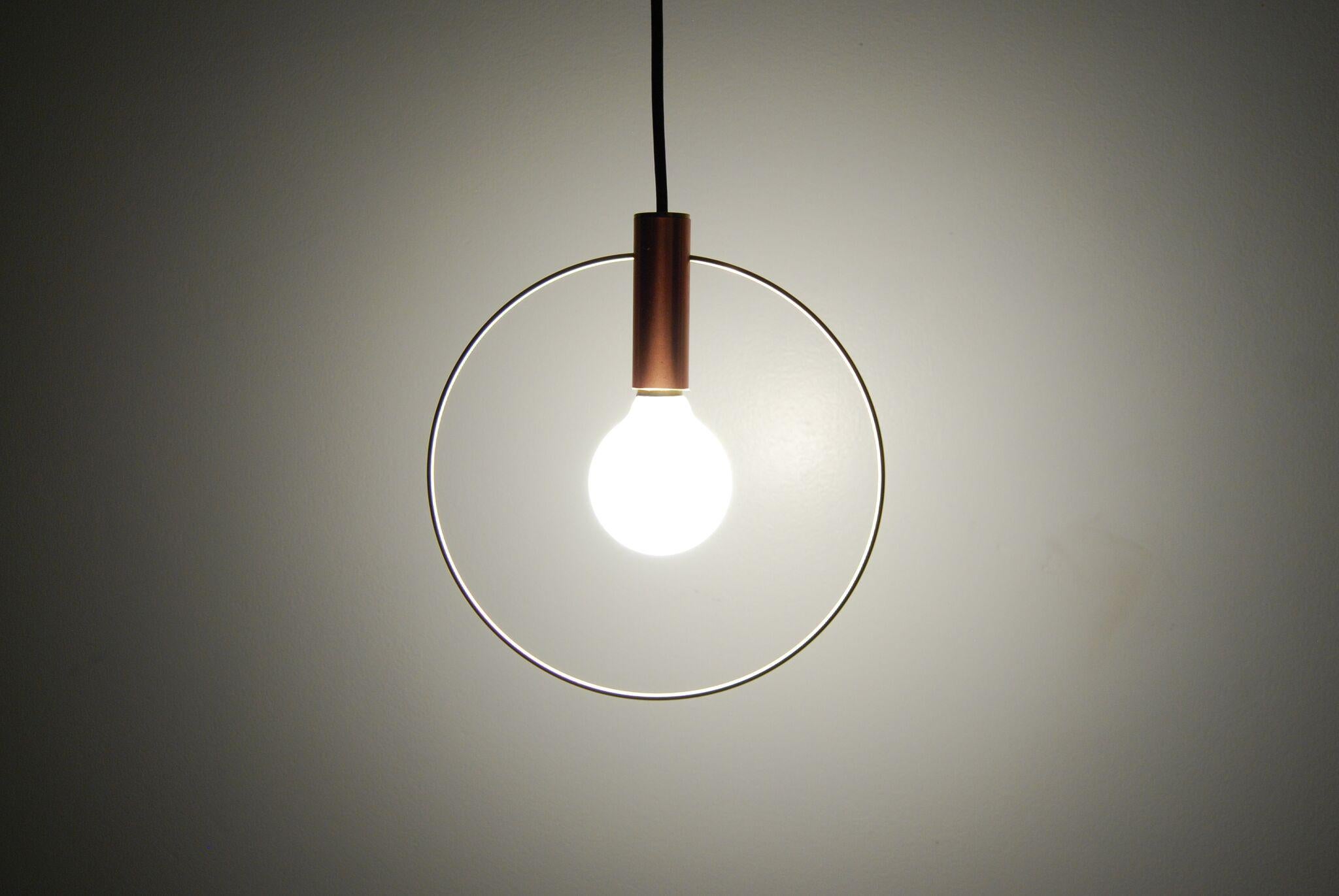 Light pared down into its two elemental ingredients: the source (the bulb) and its illumination (highlighted by a brass ring) The resulting Aura pendant lights are simple and versatile. Pendant can be hung individually at adjustable heights or in