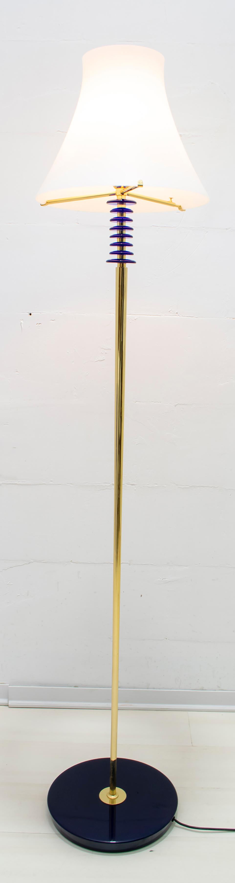 Floor lamp produced by the Murano masters Auras,
in white and transparent layered Murano glass, the structure is in brass with blue blown glass rings.