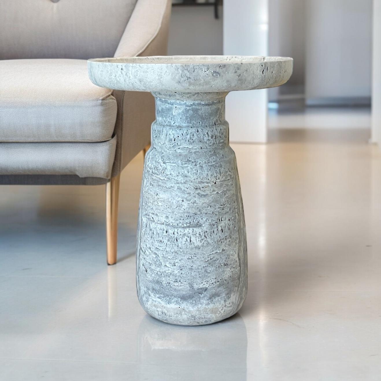 Table d'appoint 'Aurea' de HAAND, fabriquée en travertin argenté de première qualité. Cette pièce exquise mesure 13,8 pouces de diamètre et 18,5 pouces de hauteur, pour un poids substantiel de 80 livres.

La table d'appoint Aurea témoigne d'un