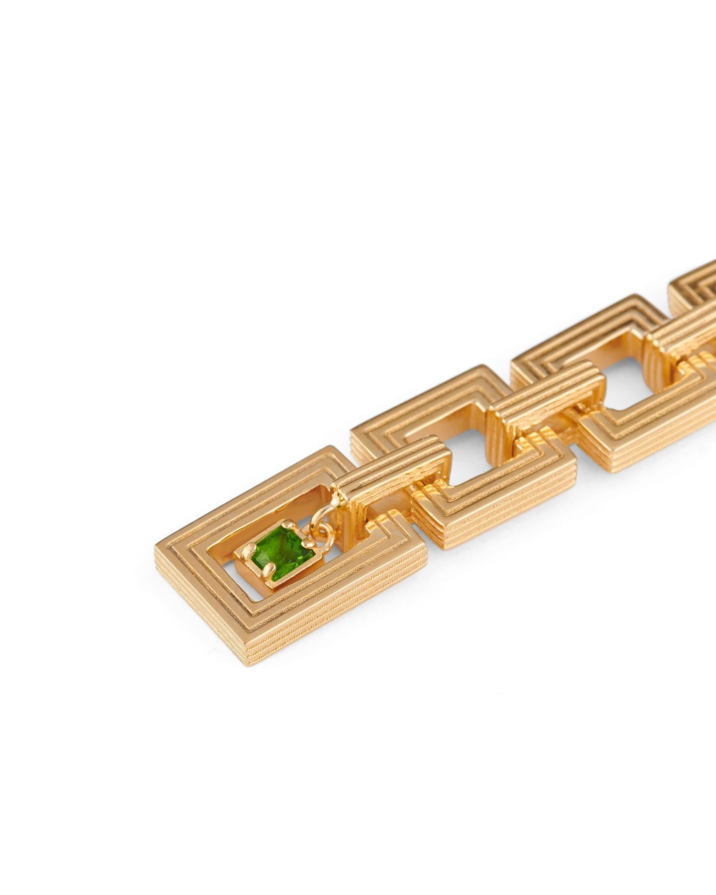 The gold-plated Aurelia earrings feature five interlocking square links that create an elegant drop. Enveloped in the last link is a faceted green chromodiopside.

Details:
925 Sterling Silver
Plated in 18K Yellow Gold
Gemstone: Green