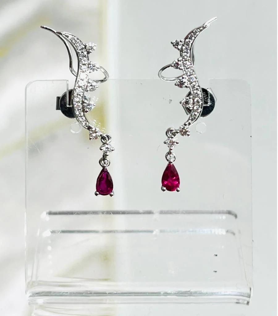 Aureliean Lover's Ruby & Diamond Ear Climbers In 18k White Gold

A pear shaped Ruby dangling ruby with dangling diamonds set on a diamond curved ear climber. 0.5cts of Rubies and are excellent quality, 0.5cts of brilliant white diamonds VS quality