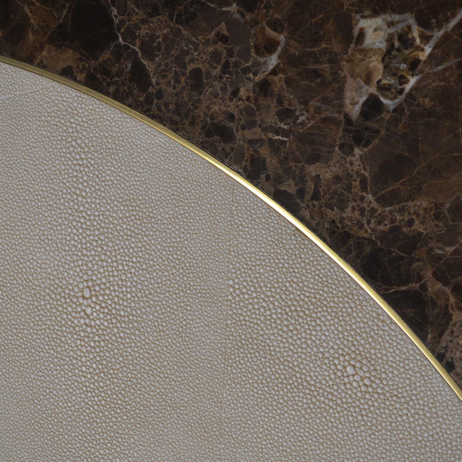 Dans la table ronde Aurelio, le galuchat scagliola rencontre l'élégance du marbre Brown Emperador et les accents raffinés du laiton poli.
L'objectif est de montrer à nos clients un nouveau concept de la technique artistique de la scagliola, où la