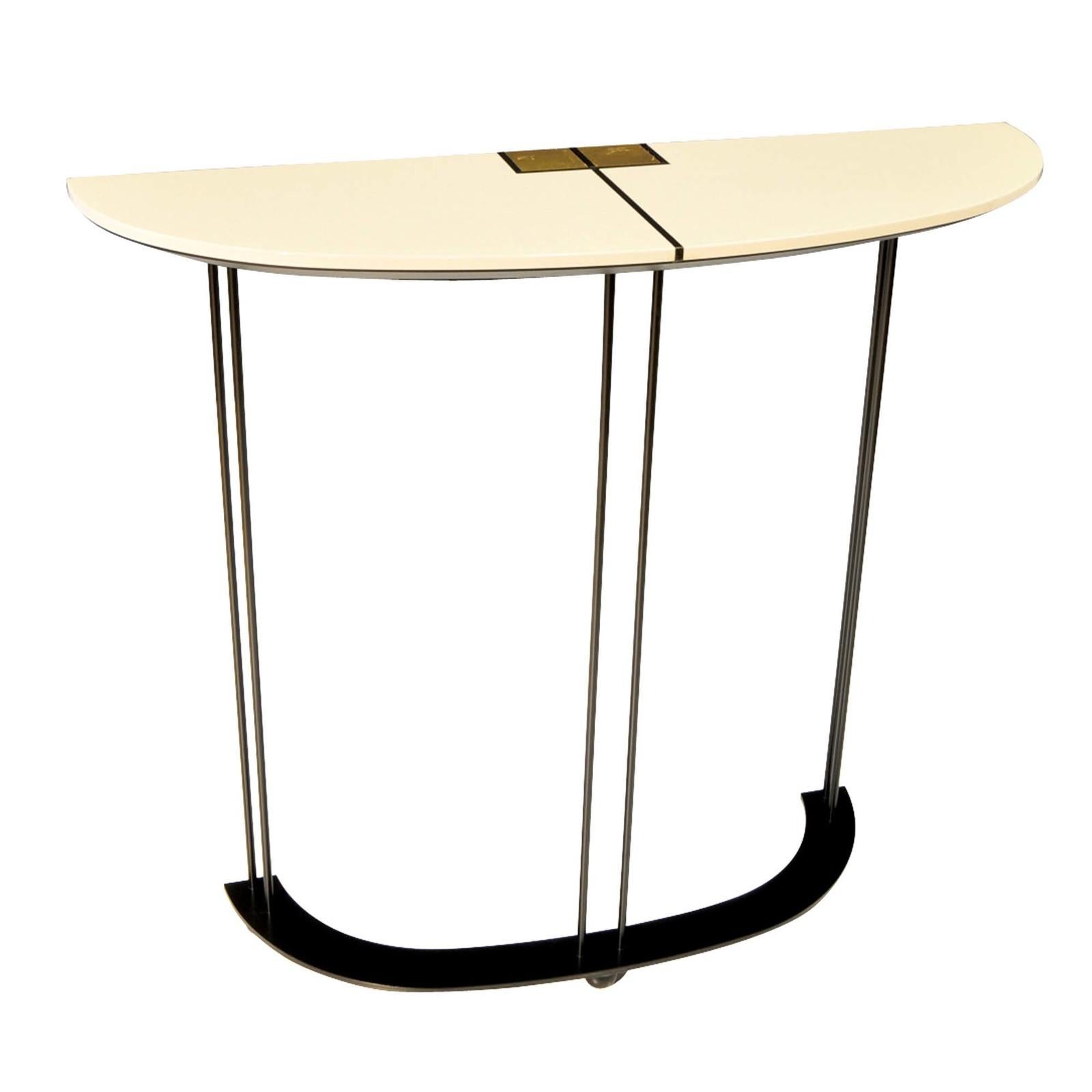 This tall console boasts a demilune profile, the wooden top finished in an off-white shiny polyurethane lacquer, which contrasts with the three open, column-like legs in a matte black powder coating. The table features a delicate cross inlay accent