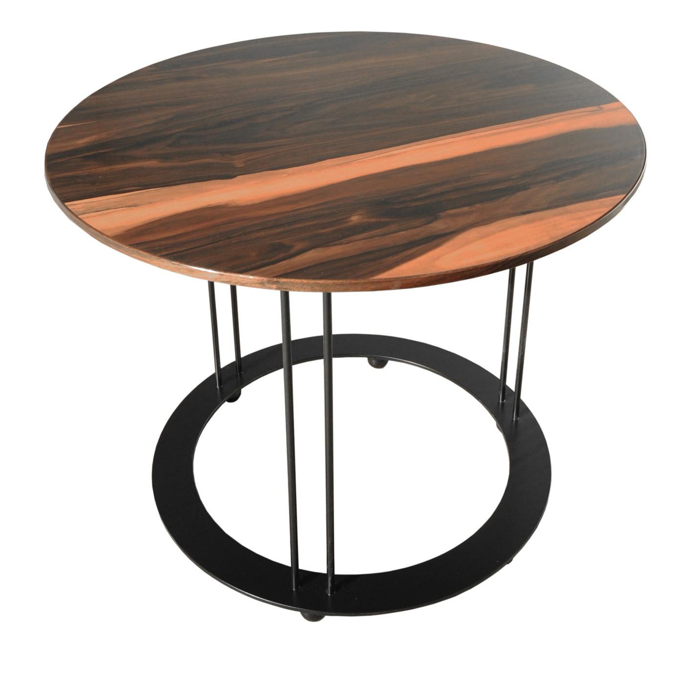 A splendid addition to a refined, contemporary decor, this coffee table will elevate the look of an entryway, hallway, or living room. Crafted of Makassar ebony, the round top showcases natural hues and superbly rests on a sturdy metal base with a