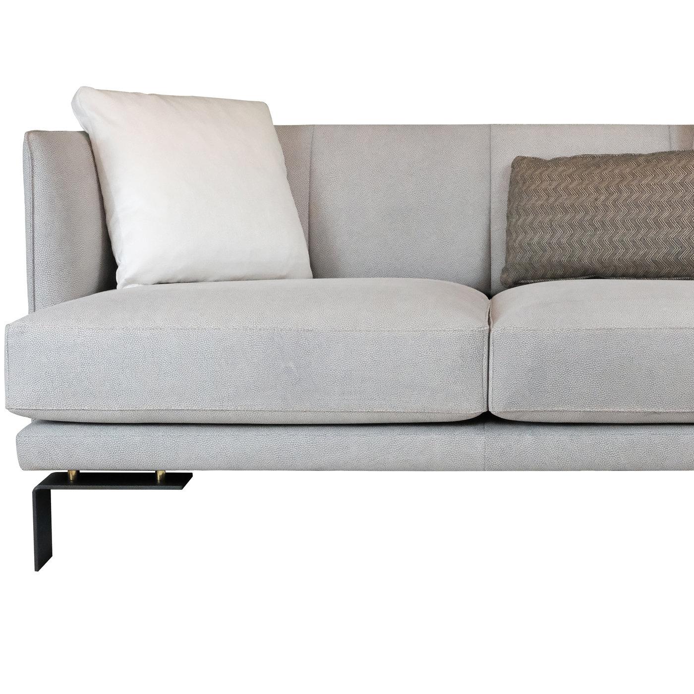 Boasting a unique, contemporary silhouette, this sofa will be a stunning addition to any interior. Its embracing silhouette is superbly mounted on charcoal gray metal feet enriched with golden details and rests on a wooden frame equipped with