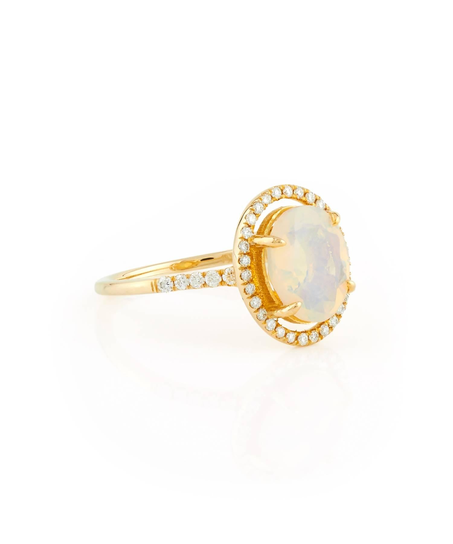 Drawing inspiration from the constellation, this gorgeous halo of round diamonds orbits around a unique oval opal. This ring in photos is a size 5.5 and ready to ship. Please contact for another size.

• 18kt yellow gold
• Ethiopian Welo opal & VS+