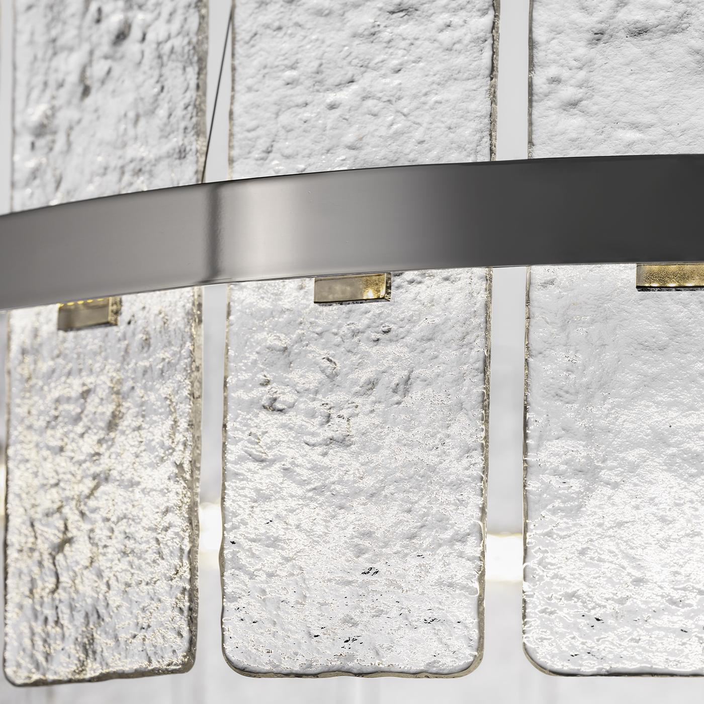 Aurora circle chandelier features a contemporary metal frame with a nickel finish and frosted rectangular glass panels that softly diffuse light. Its integrated LED strip with included transformer provides indirect illumination, creating a warm and