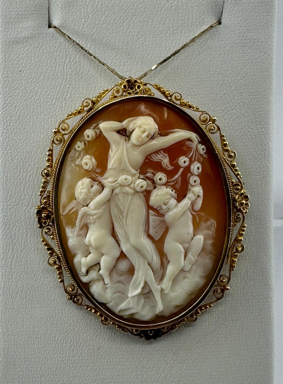 Dies ist eine absolut atemberaubende Museum Qualität antiken viktorianischen Shell Cameo Anhänger oder Brosche in 18 Karat Gold mit einem handgeschnitzten Bild einer Göttin Maiden Streuung Rosen mit zwei begleitenden Cherub, Engel oder Putti in den