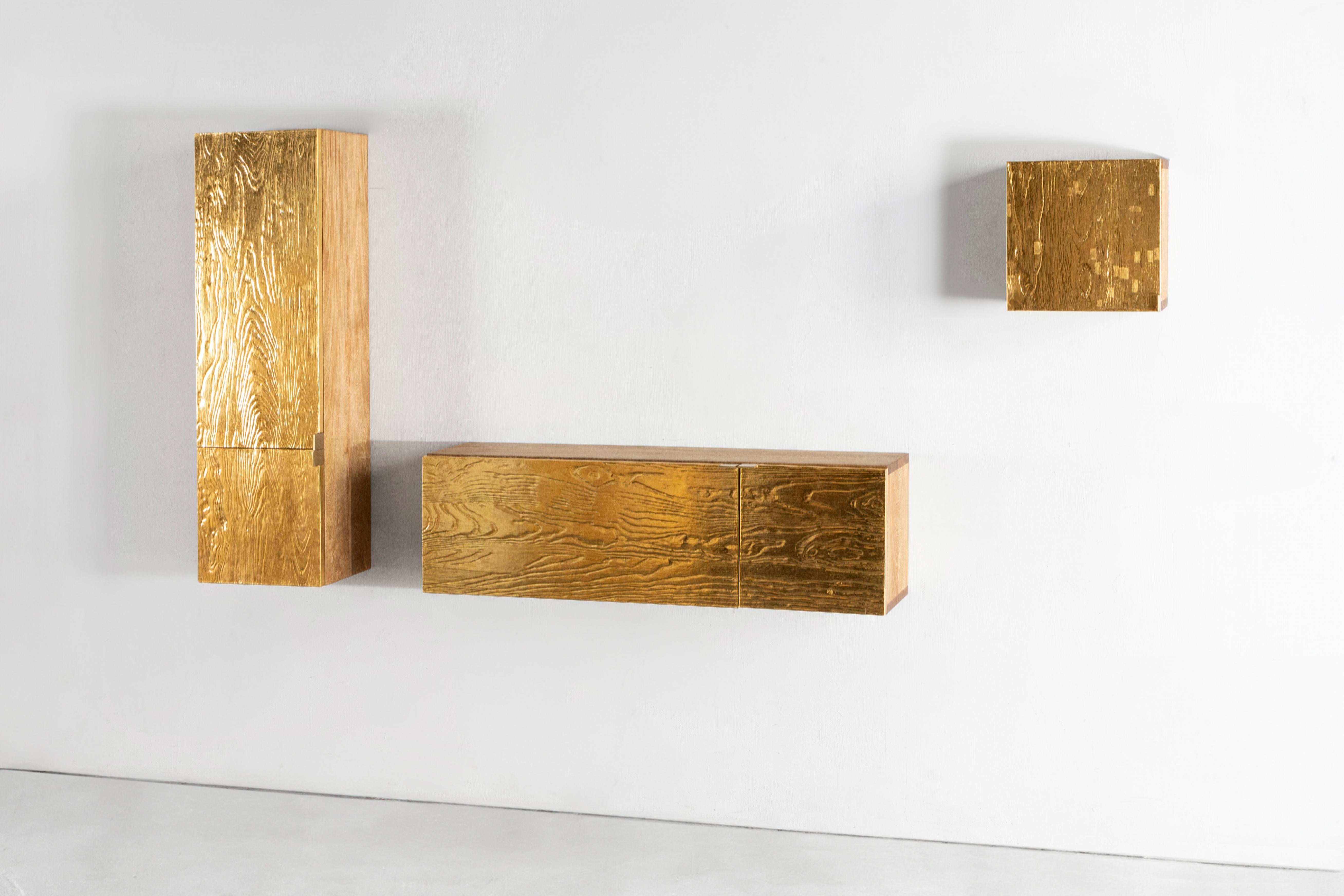 This set of boxes and a credenza was created through a meticulous process reminiscent of the creation of church altarpieces. Each is a tiny piece of architecture, made from sandblasted wood and covered with fine 23-karat gold leaf. Traditional