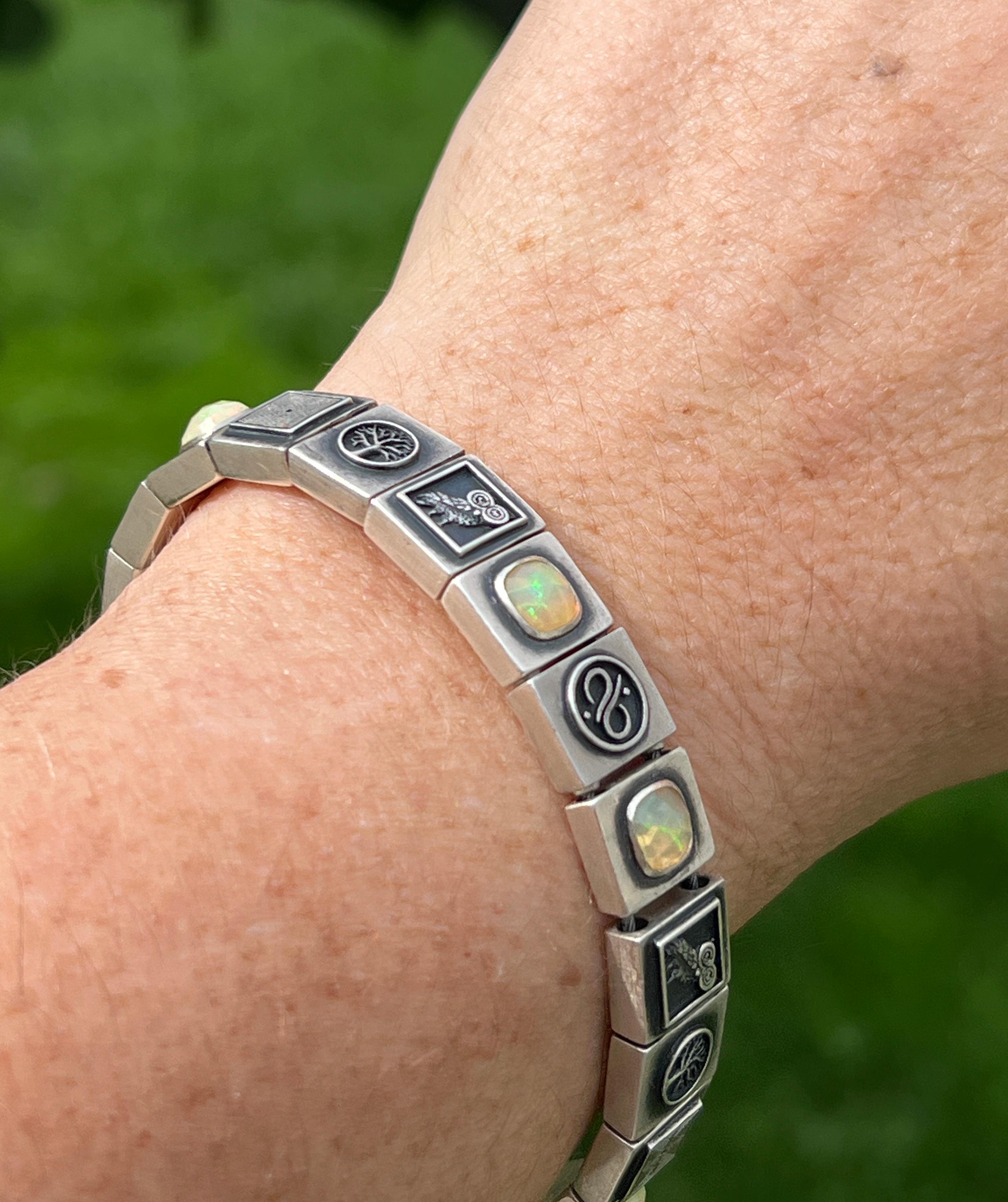 Experience the fusion of luxury and ancient symbolism with the Owl of Minerva Opal Bracelet from Aurum Brothers' Varnos Collection. This remarkable bracelet features rose-cut cushion opal gemstones set in solid 925 sterling silver, adorned with