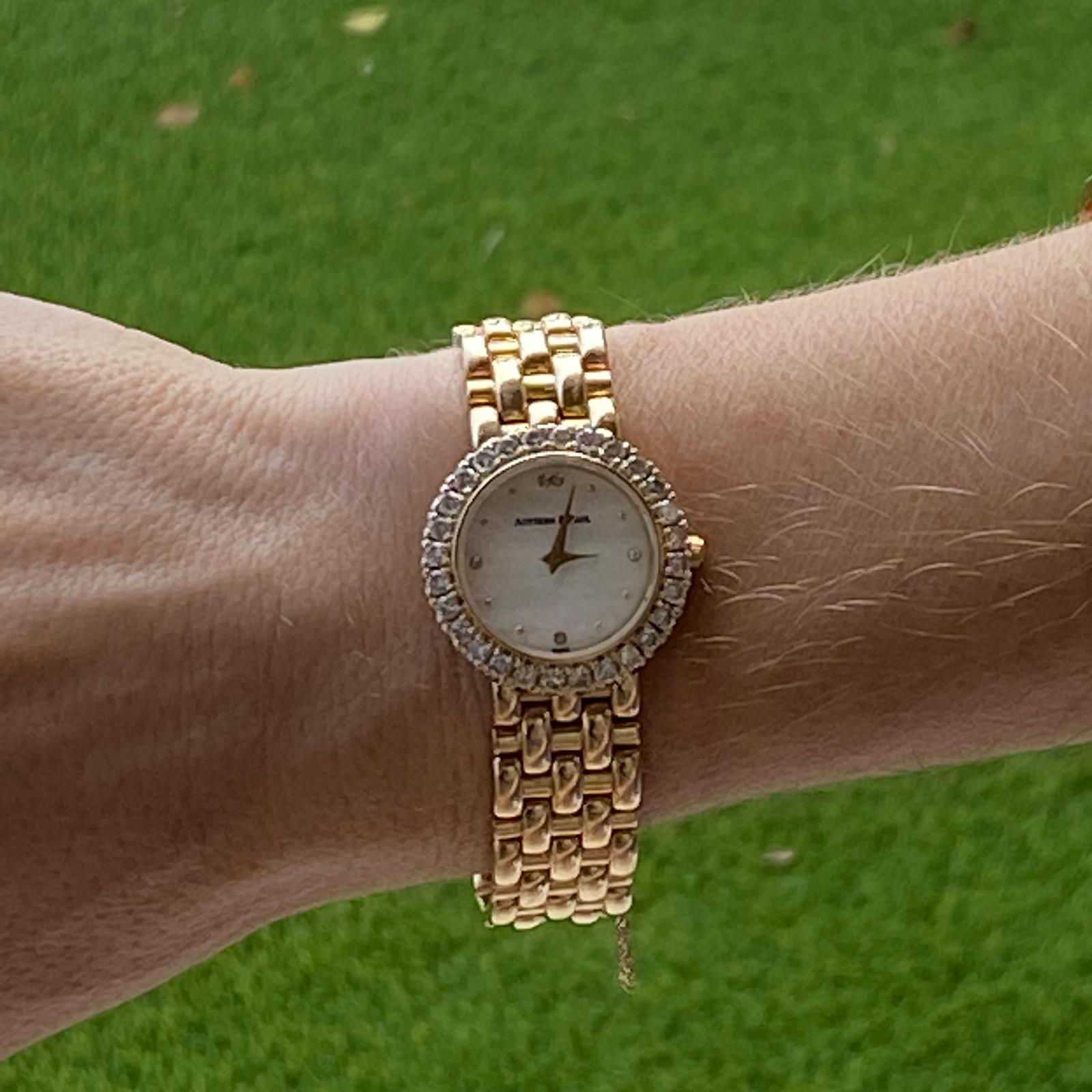 Austern & Paul 28mm ladies watch fashioned in 14 karat yellow gold. The watch features a mother of pearl dial, diamond bezel weighing approximately 1.50 carat total weight, and gold link bracelet. New battery, all original links, and perfect working
