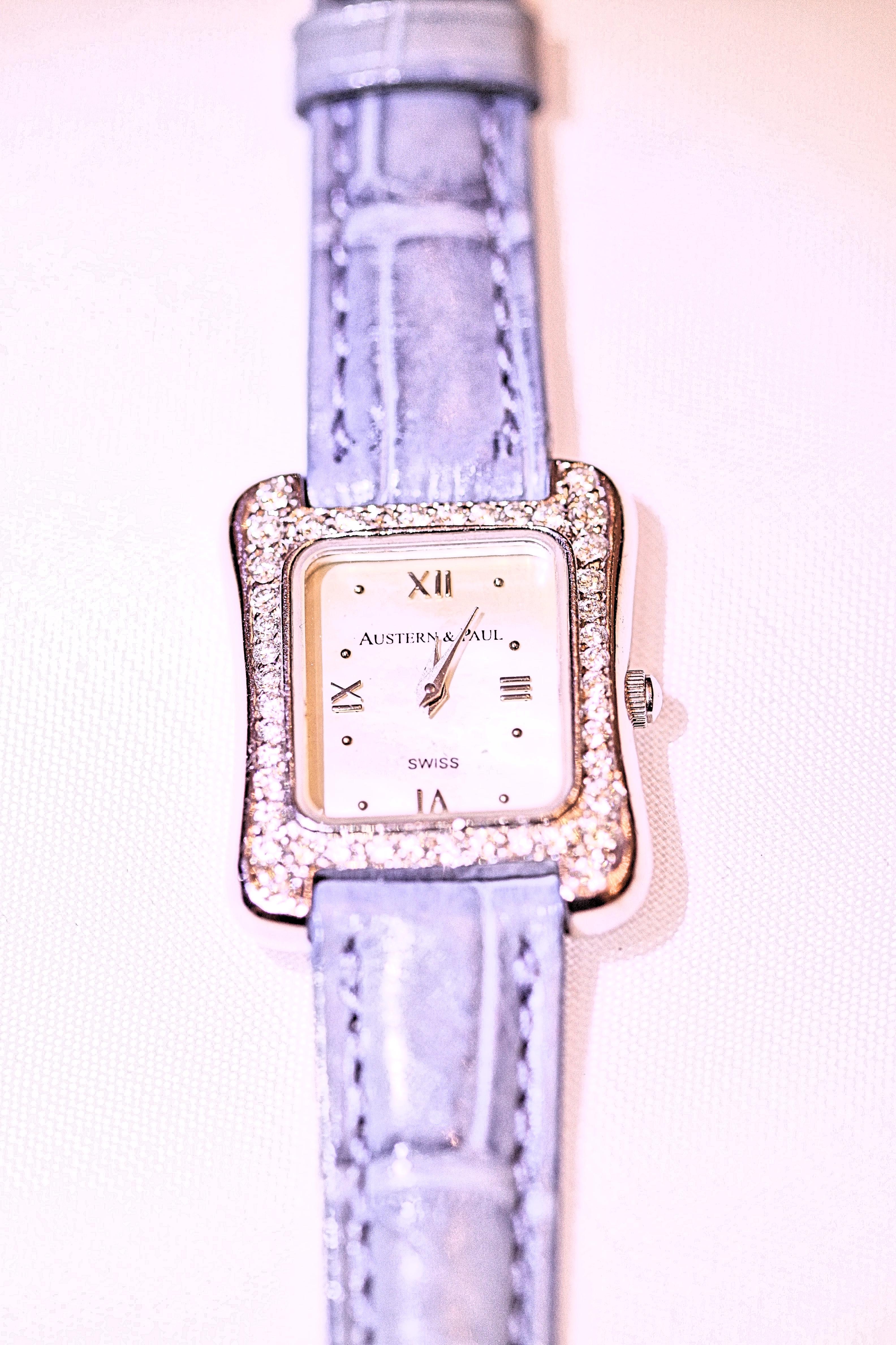 A charming 14 karat white gold ladies tank watch.  The watch has .45 carat total weight of round brilliant cut diamonds.  The watch is a quartz with a mother of pearl dial.  The watch measures 26 x 20 mm.  The leather strap is a blue alligator with