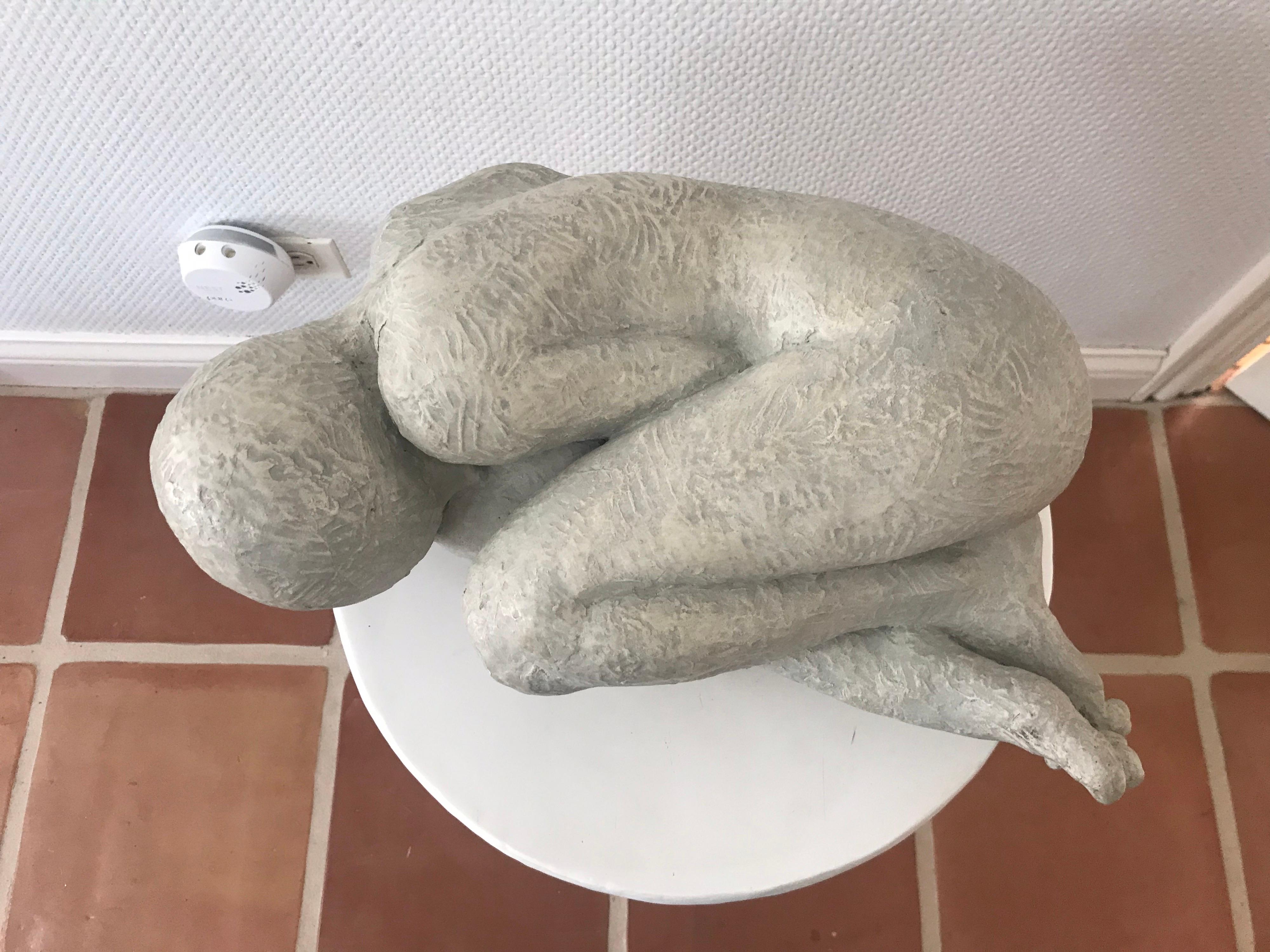 This is a ceramic sculpture of a figure in a fetal position
The gray colored sculpture is signed Barnhill and has imprint of Austin production ltd.