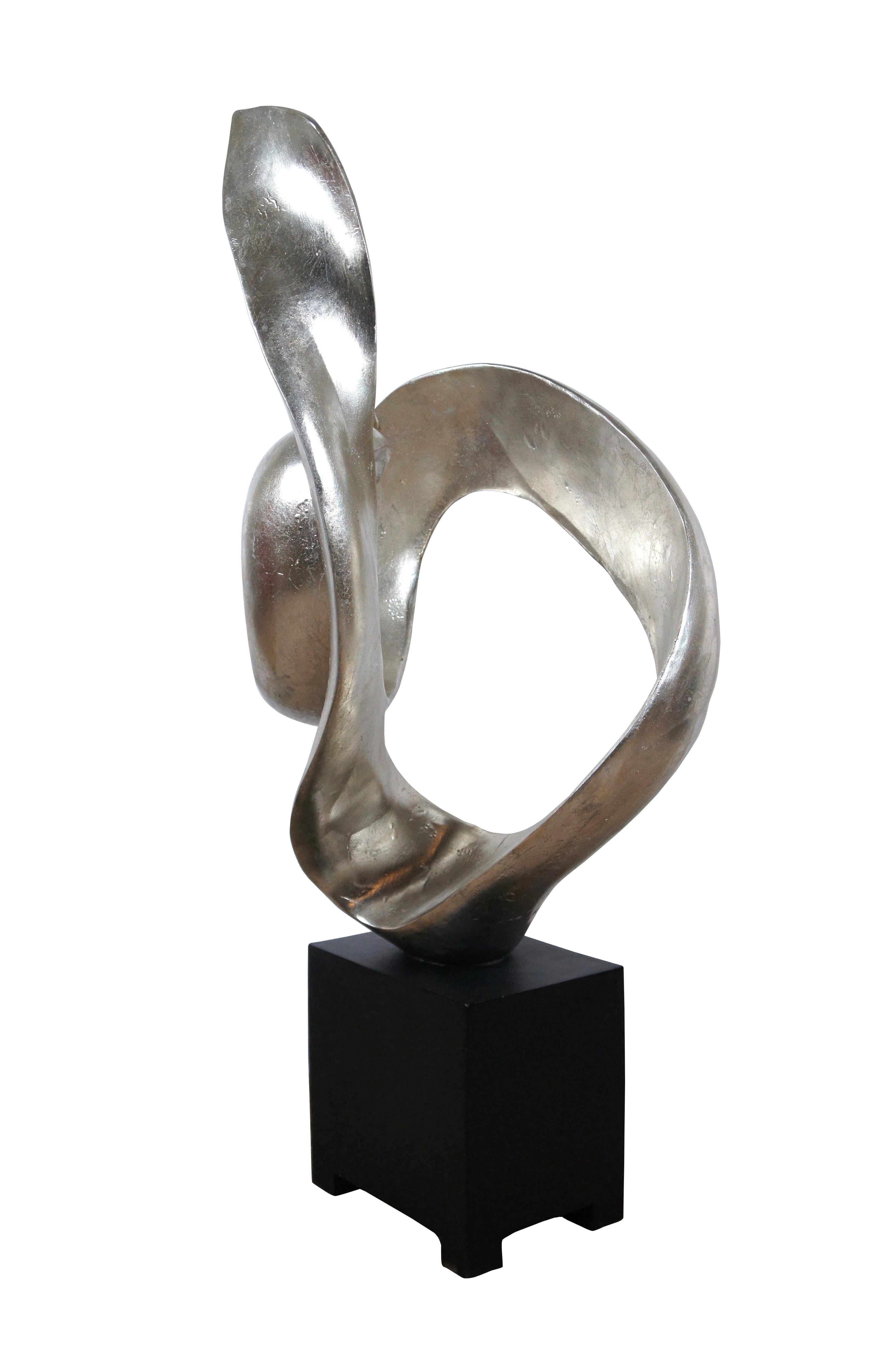 Late 20th century composite sculpture by Austin Productions featuring a rectangular black base supporting a silver gilt swirling abstract shape.

Dimensions:
18