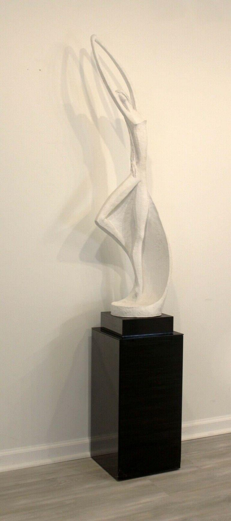 From Le Shoppe Too in Michigan, this cast plaster sculpture is figurative in nature depicting a woman in movement. Sitting atop a marble base, this sculpture would be an elegant addition to any aesthetic. Signed by Austin Productions and dated