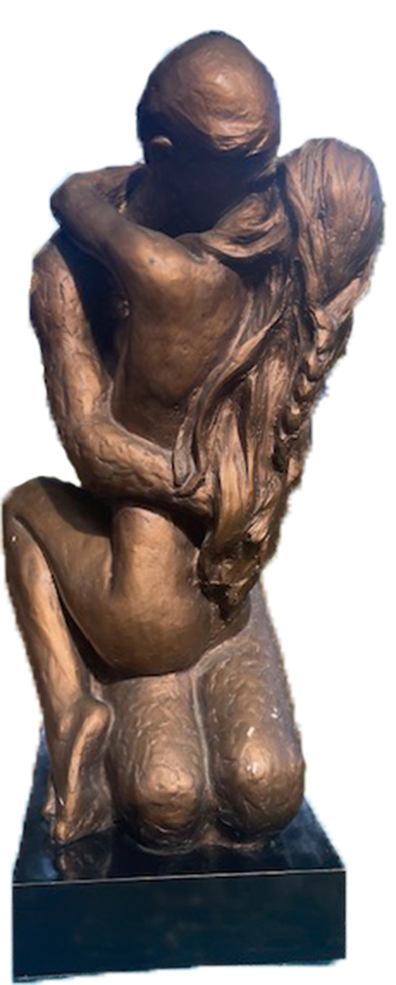 Two nude figures hold each other in a tender embrace, their eyes closed and hair spilling over their shoulders and across their backs. Although rendered in resin, a patina was added to recreate the effect of bronze. This piece is similar to a work