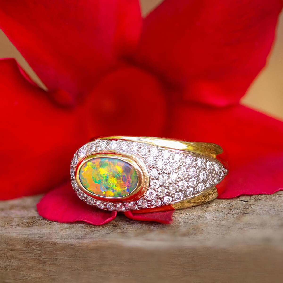 Elegant and sophisticated, this stunning solid 18K yellow and white gold ring features a mystical solid Australian Black Opal with shimmering orange, yellow, blues and greens that take you into its depths and hold your imagination in awe. 

The