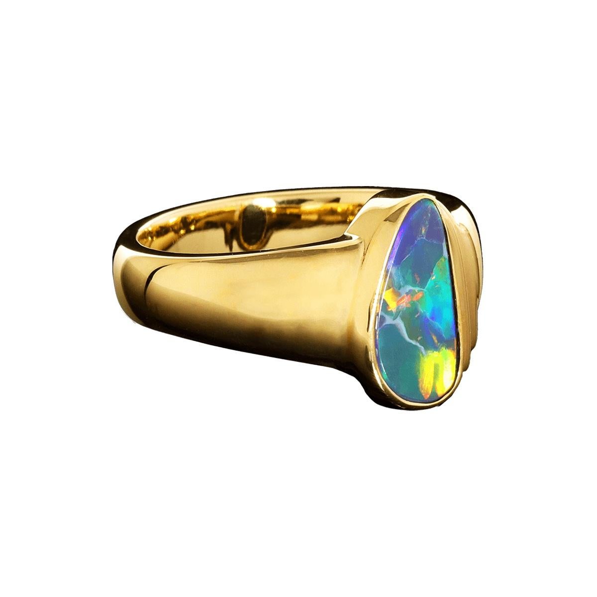 A beautiful flagstone pattern solid Australian Black Opal set in solid 18K gold and accented with brilliant white diamonds. A ring for every occasion and perfect to be worn daily. High-quality gem-grade Black Opal with purples, blues, yellows,