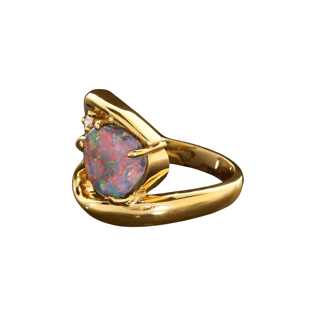 Schmuck ist tragbare Kunst, und dieser atemberaubende Ring ist da keine Ausnahme. Der hochgewölbte schwarze Opal mit seinen leuchtenden Rot-, Orange-, Violett-, Grün- und Blautönen ist ein wirklich einzigartiges Stück. Ein funkelnder weißer Diamant