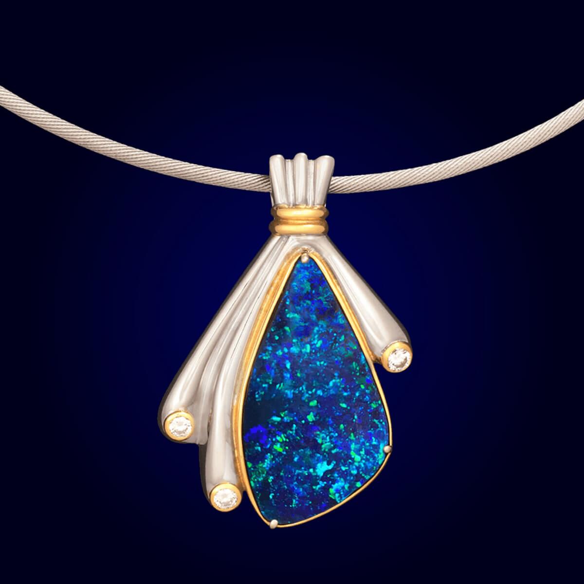 This stunning piece is a very unique solid Australian Boulder Opal. Deep mysterious blues and greens draw you into the stone that seems to go on forever. Set with high jewellery grade diamonds, solid platinum and 18K gold, this pendant is a