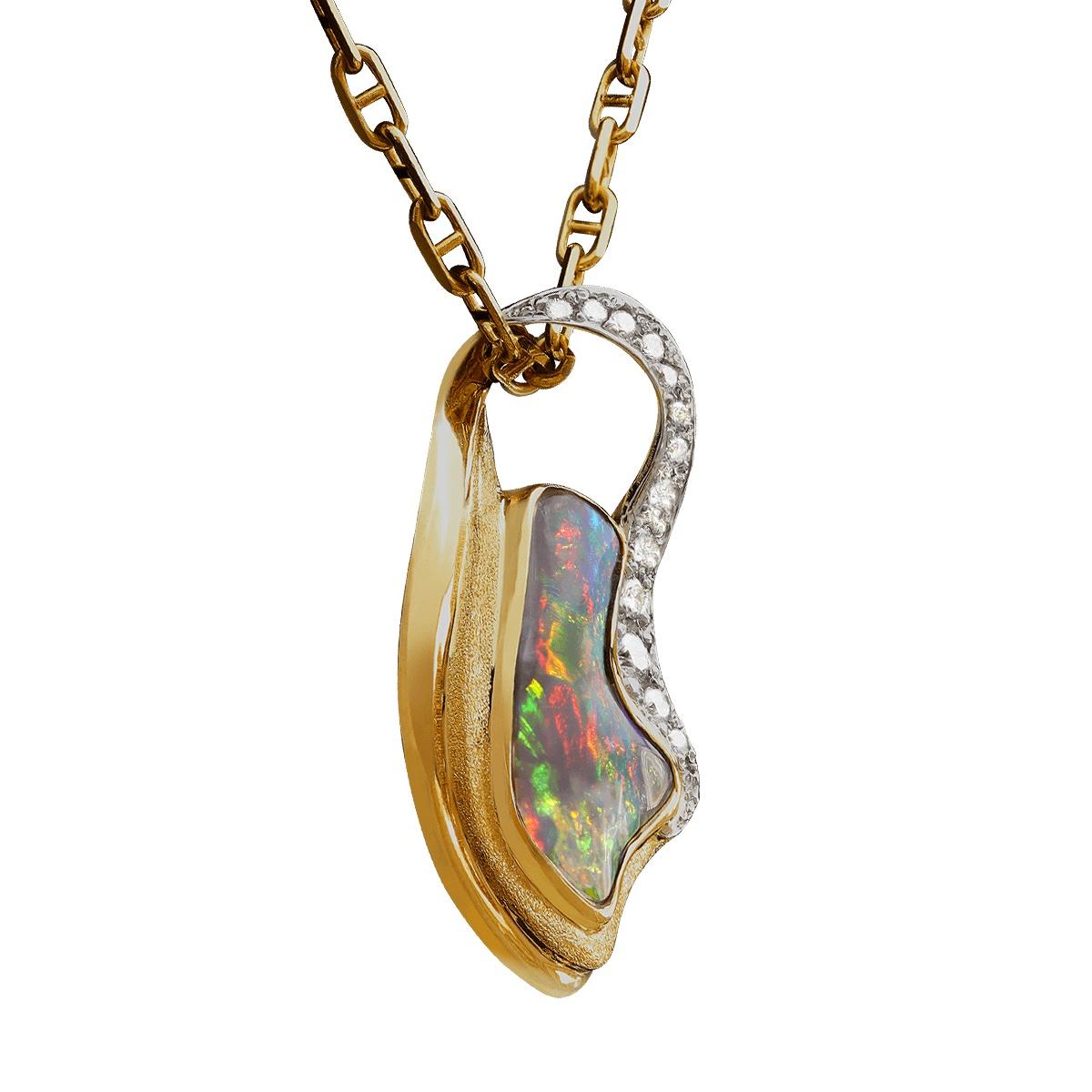A dark red on black is the most sought after colour combination in all opal. This opulent pendant holds a freeform shaped black opal surrounded in 18K yellow gold and high jewellery grade brilliant white diamonds that are set in