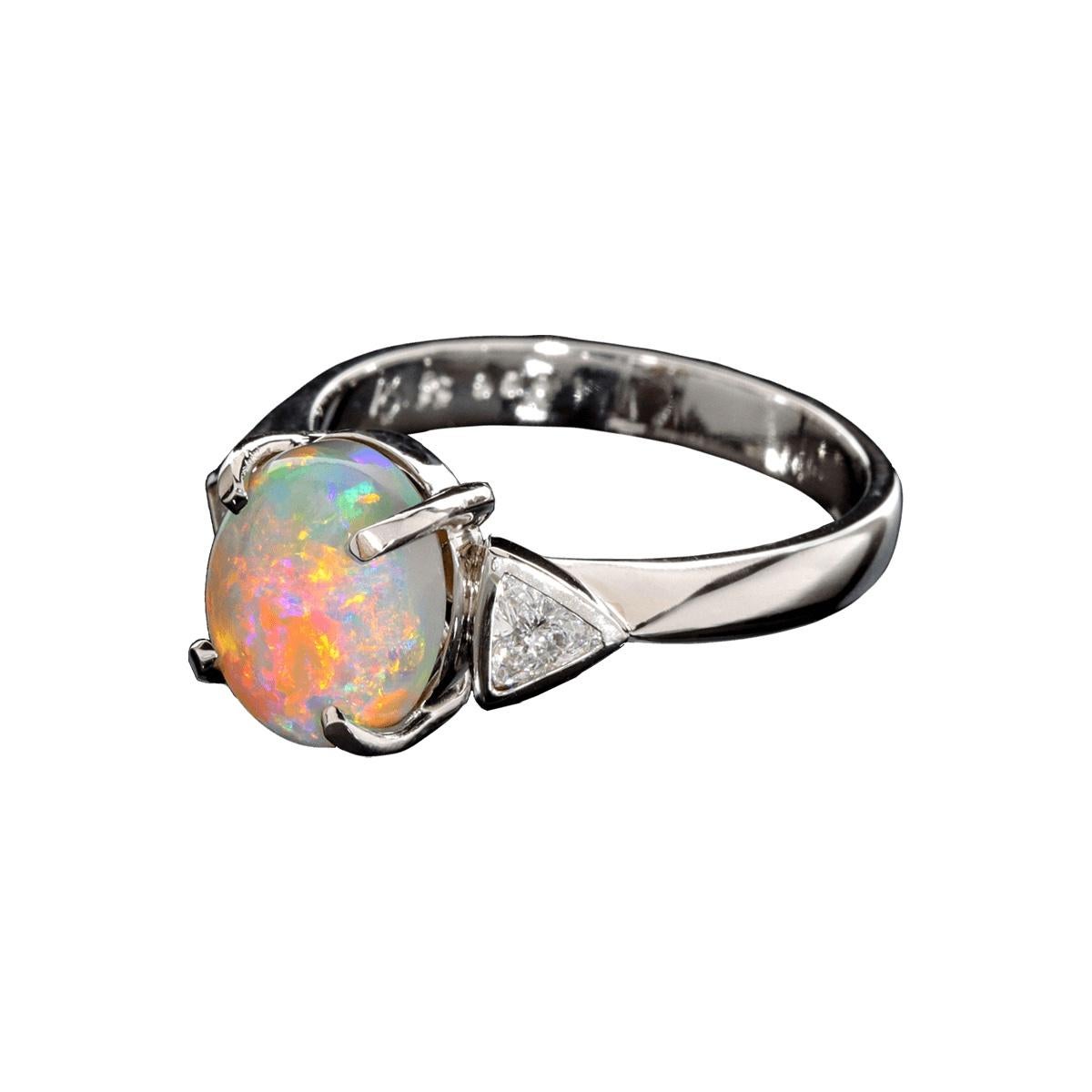 Sophisticated yet minimalistic in its design, this amazing solid platinum ring sports a stunning solid Australian dark Crystal Opal and two large brilliant white diamonds. Red is the rarest and most sought after colour in opal and this gem has