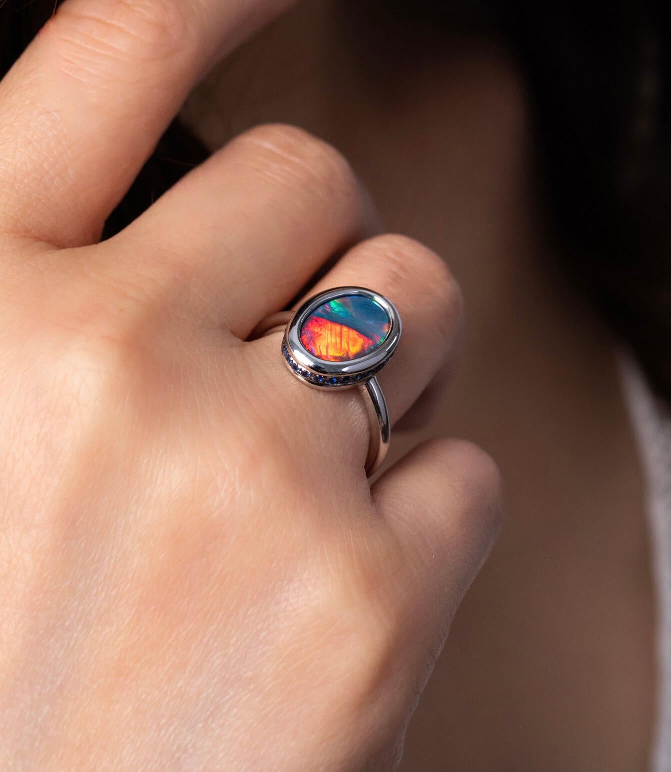 “Fire and Desire” black opal ring epitomises the paradox of passionate love. This exceedingly rare two-tone black opal (2.83ct) makes an arresting jewellery piece with its distinct two-tone play-of-colour. A circle of brilliant-cut sapphires in 18K