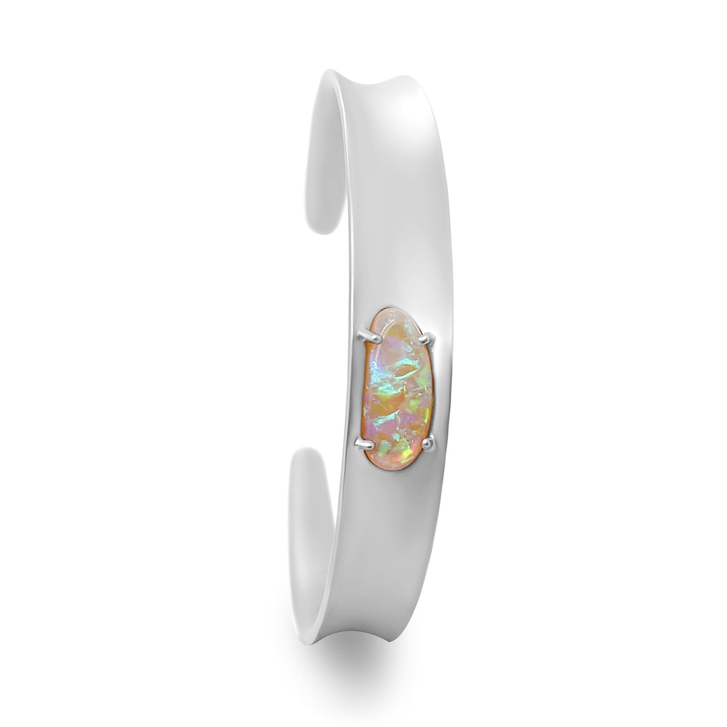 An understated yet charismatic piece is the 'Vorfruede' bracelet cuff featuring an entrancing Australian boulder opal at its center. The opal gemstone itself is electrifying with its rainbow play-of-colour emphasized by the elegant setting and