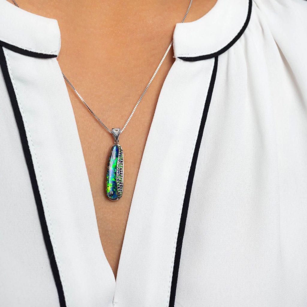 Our “Rapunzel” opal pendant embraces a freeform pipe opal (5.93ct) from our own mines in Jundah-Opalville. A delicate strand of glistening diamonds and blue and green sapphires set in 18K white gold echo this beauty’s colour-play. Wear it with denim