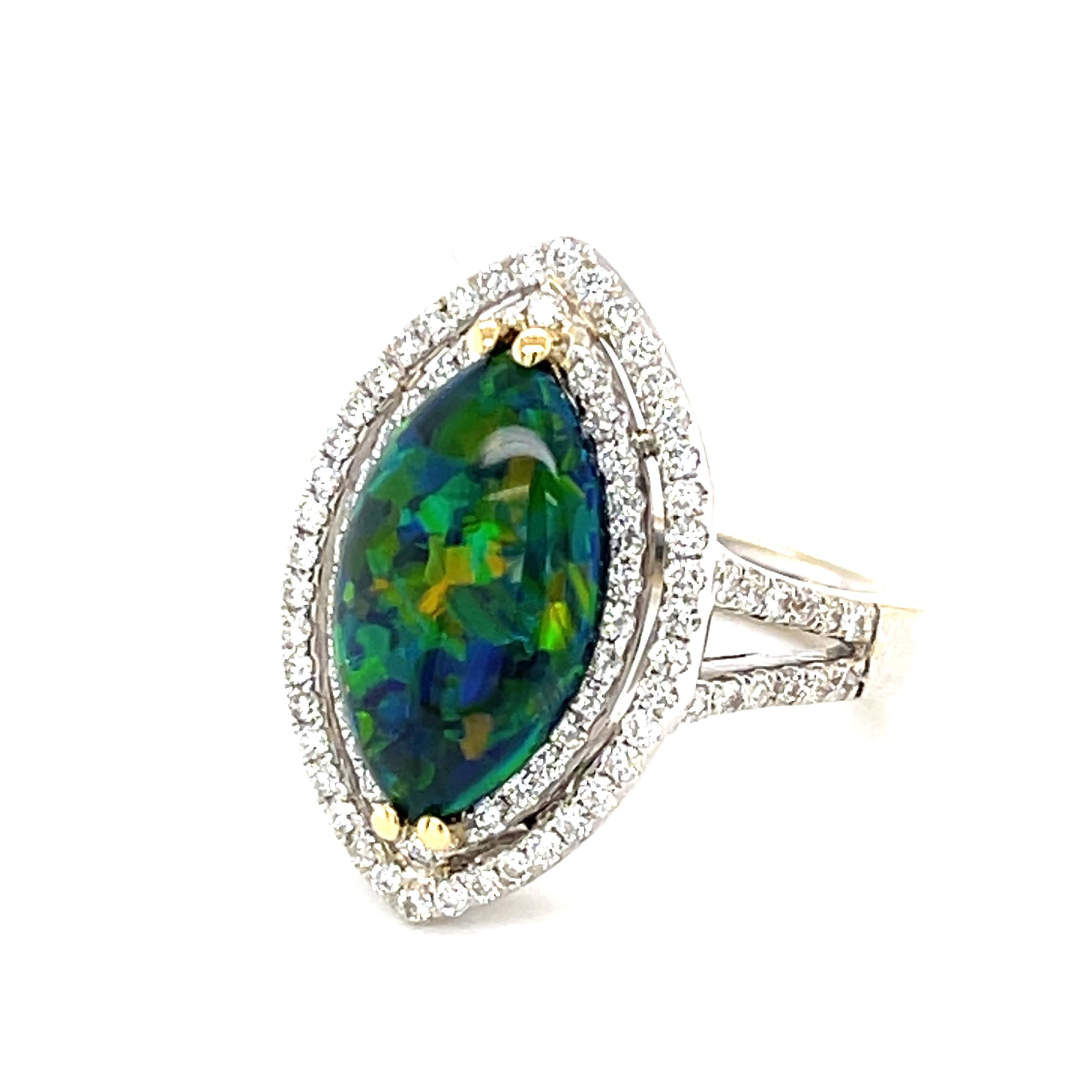 Cette spectaculaire bague en or blanc 18 carats est ornée d'une opale noire multicolore et vibrante provenant de la mine de Mintabie en Australie. L'opale de 3,15 carats présente un jeu de couleurs bleu, vert, orange et jaune saisissant. Elle a été