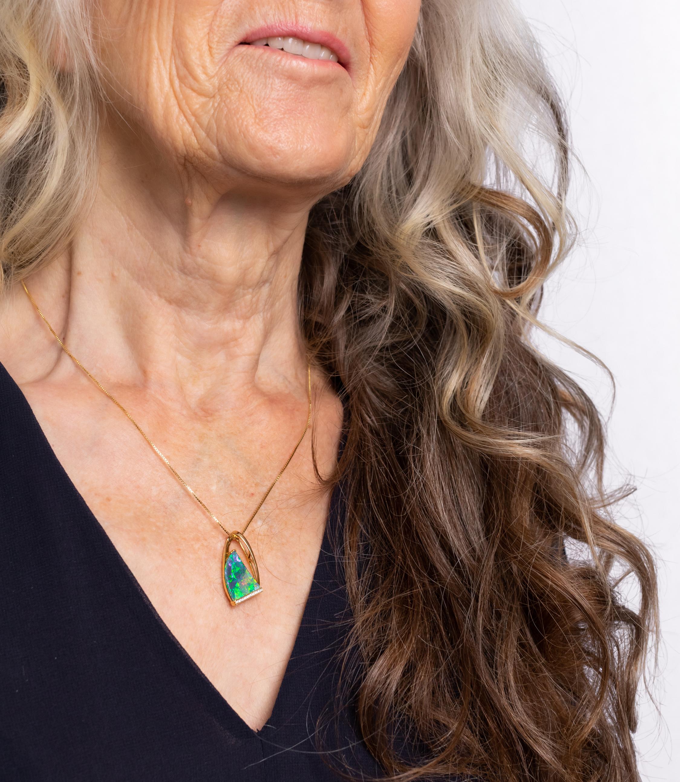 'Isadora' opal pendant is named after 'Mother of Modern Dance', Isadora Duncan. The vividly coloured Australian black opal (4.21ct) displays an intense green, indigo and gold colour-play that strikes a perfect balance with its hem of 18K yellow