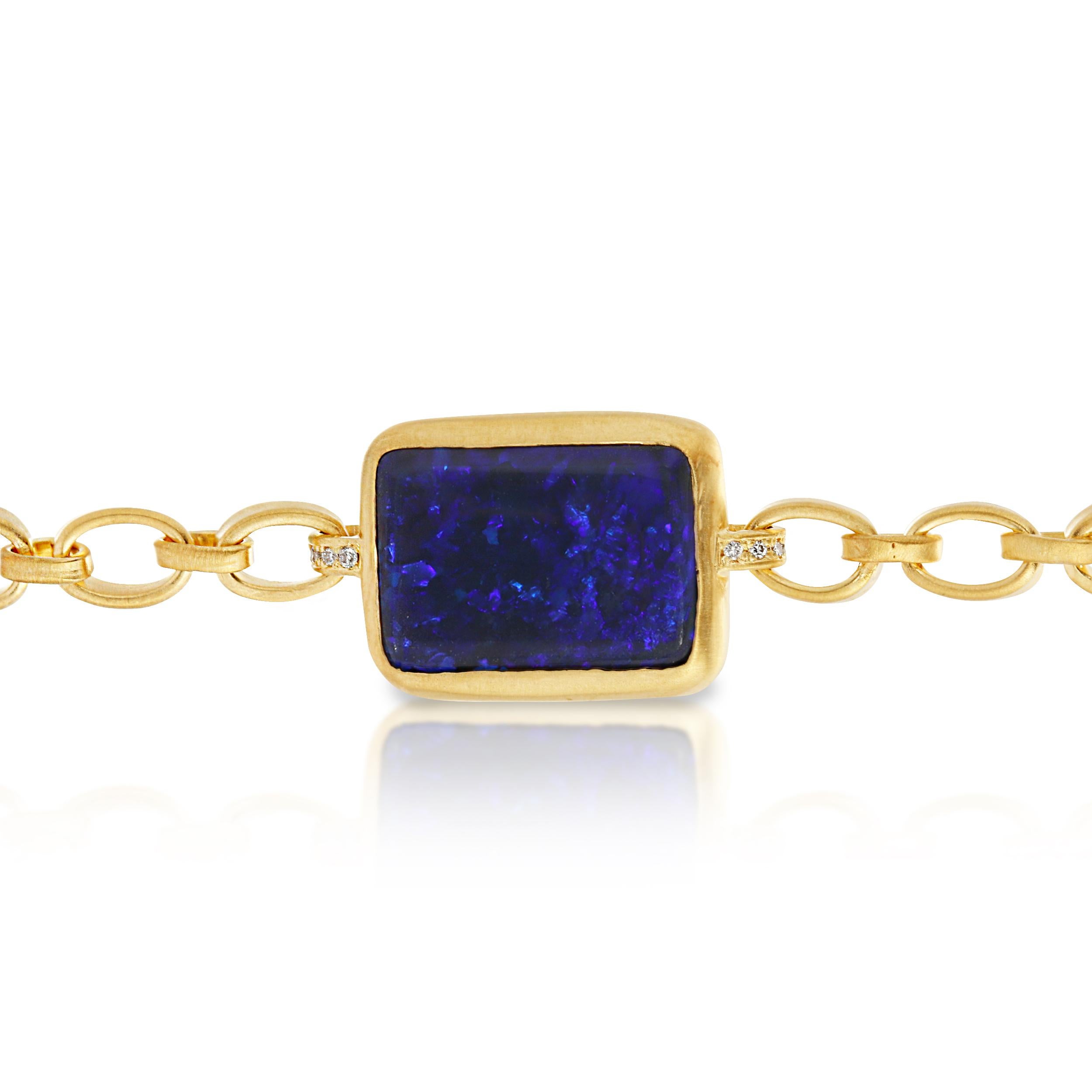 This 6.0ct  Australian Black Opal is Bezel Set in Matte 18k Yellow Gold with .10ct Diamond Accent on the loops connecting the Opal to the Completely Handmade Chain and flower detail on the back. The bracelet has a Handmade Toggle Closure with