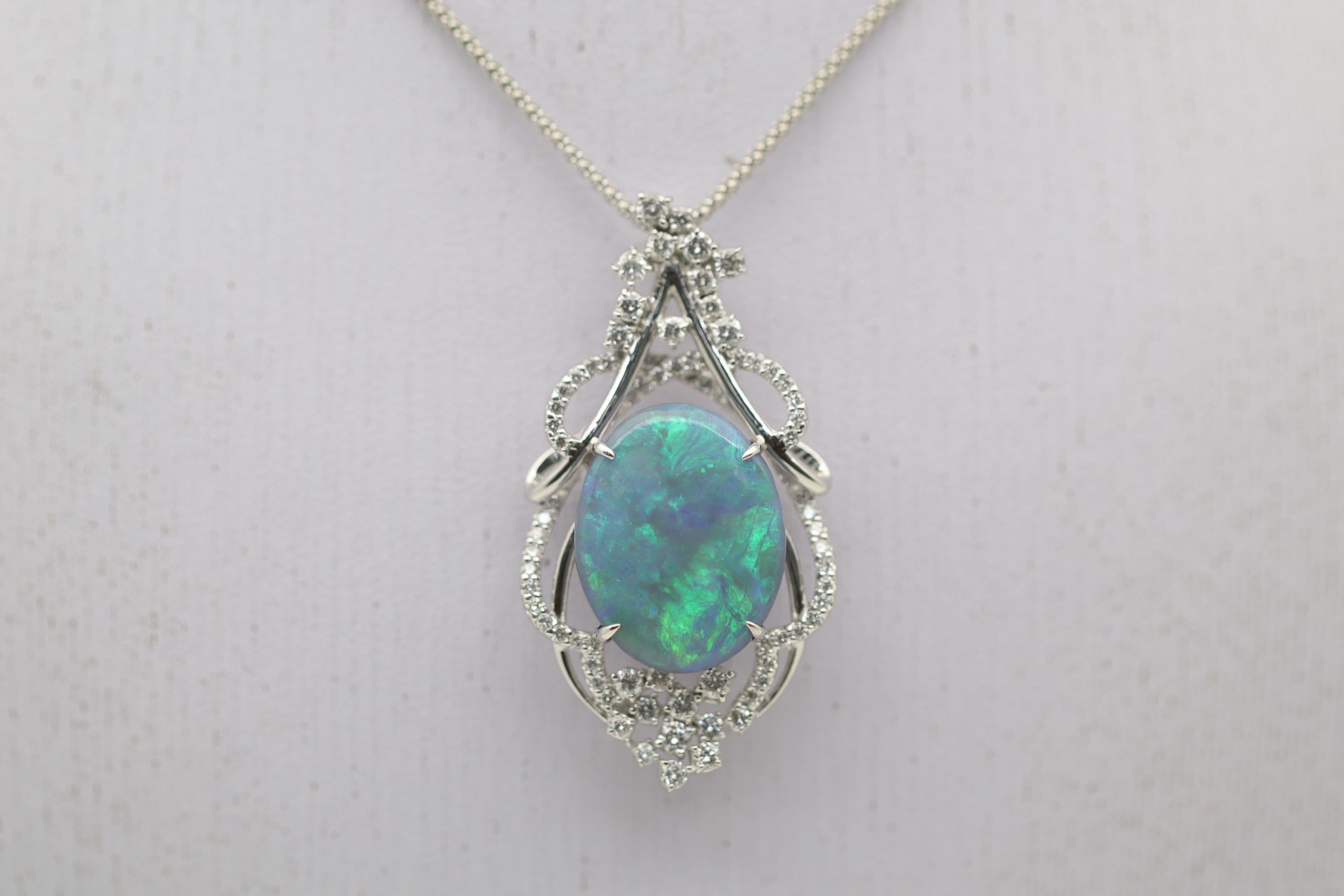 A large and impressive black opal from Australia takes center stage of this lovely gold made pendant. The opal weighs exactly 10.00 carats, is completely natural with no treatments, and has great play-of-color as primarily green with some blues