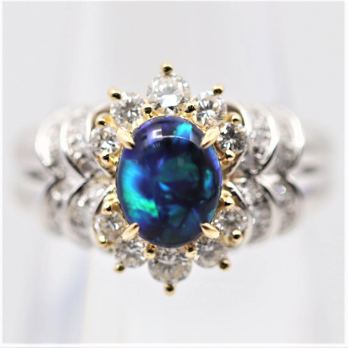 A sleek and stylish ring featuring a 1.30 carat black opal from Australia, Lighting Ridge area. It has excellent play of color as bright flashes of blue and green dance across the stone as it is moved. It is accented by 0.69 carats of round