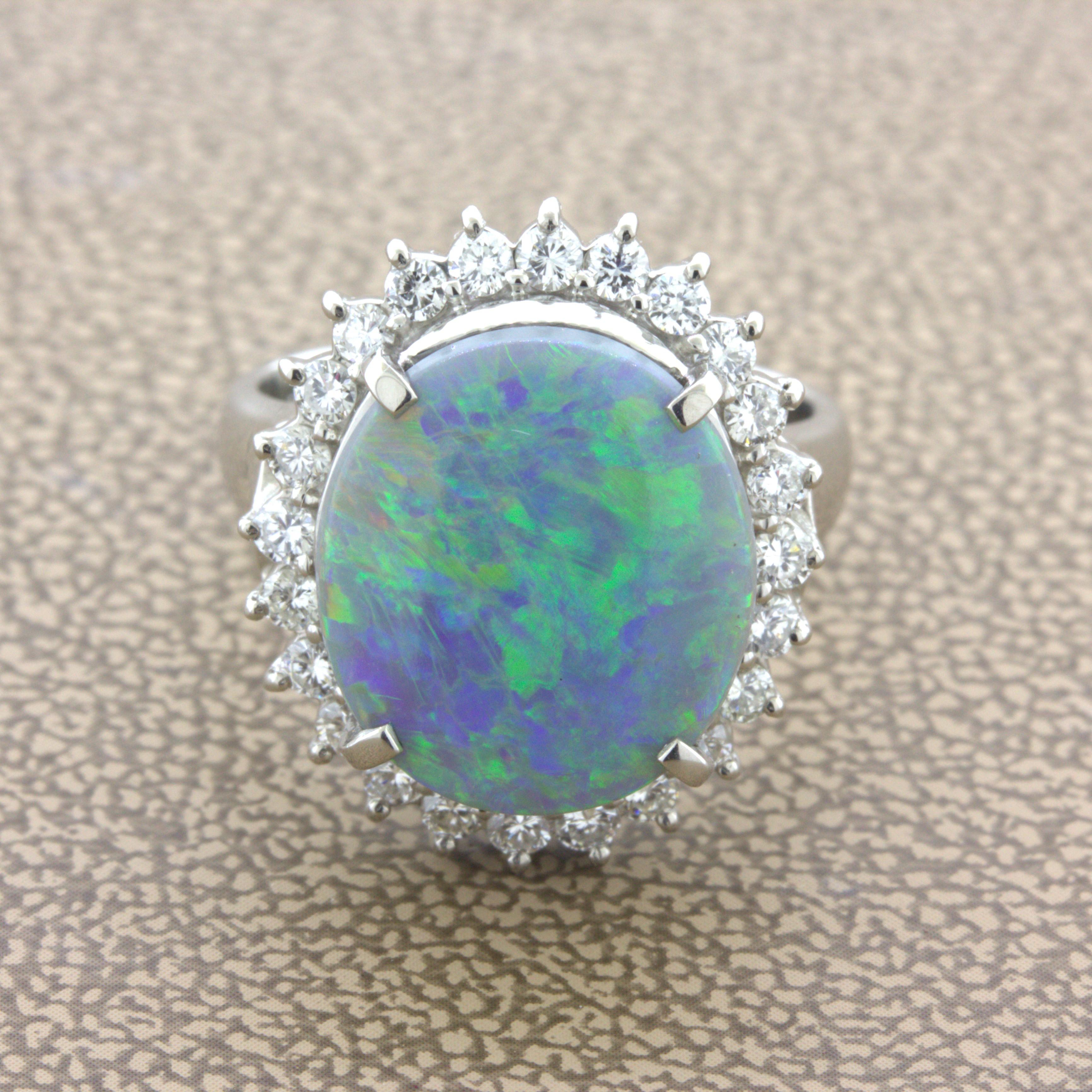 A lovely Australia black opal and diamond ring hand-fabricated in platinum. The opal weighs 4.44 carats and has strong play-of-color as various colors can be seen across the stone. Colors include green, orange, yellow and blue. It is complemented by