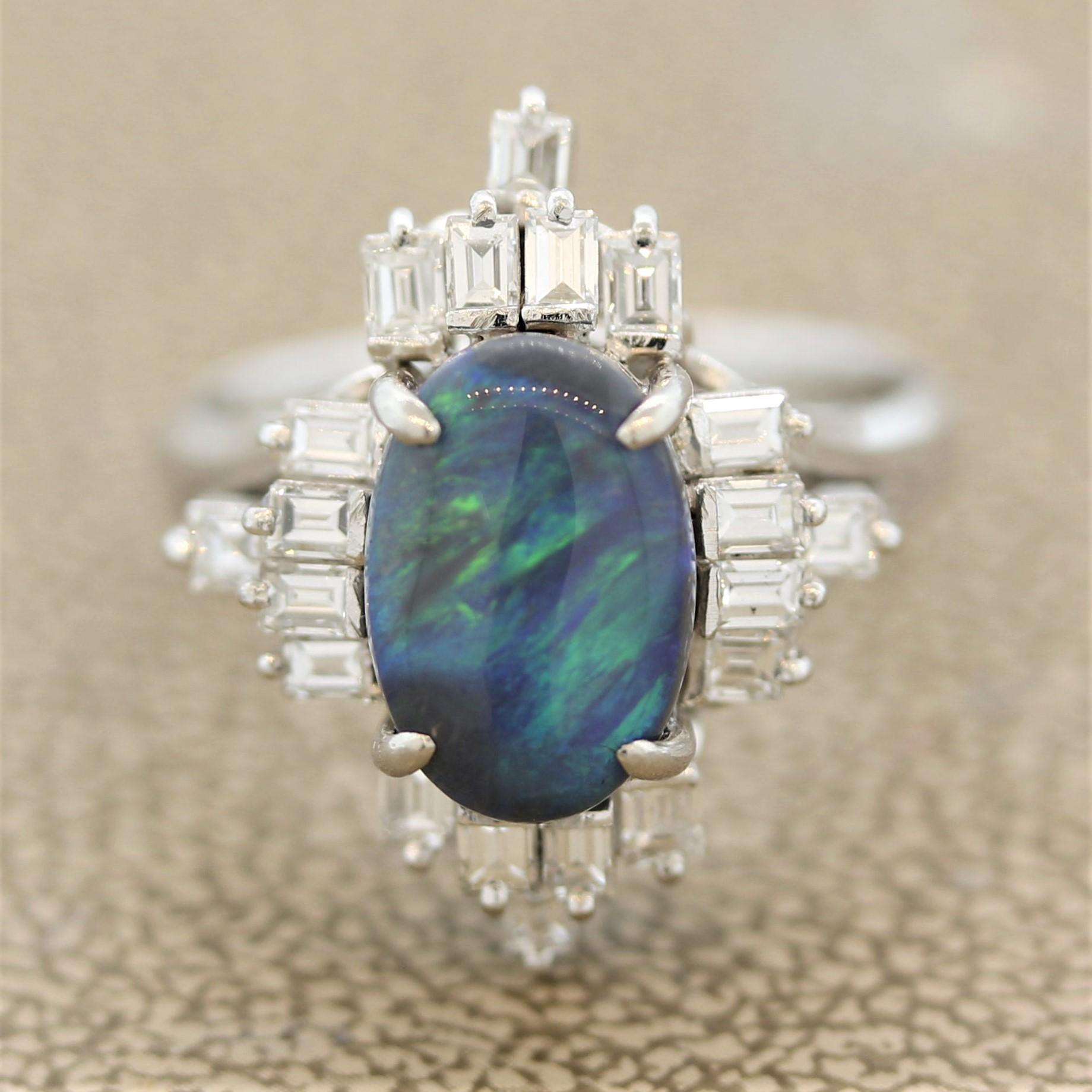 A sweet ring featuring a 2.20 carat natural black Australian opal. It has flashes of green and blue reminiscent of the northern lights. It is accented by 0.79 carats of fine baguette cut diamonds set around the opal. Hand-fabricated in a platinum