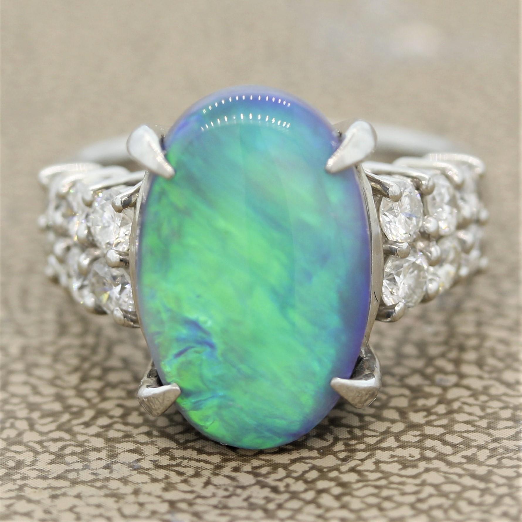 A fine and natural opal from Australia. It weighs 5.91 carats and has excellent play of color. As you turn the stone large flashes of green and blue will appear and completely cover the stone. It is accented by 0.92 carats of round brilliant cut