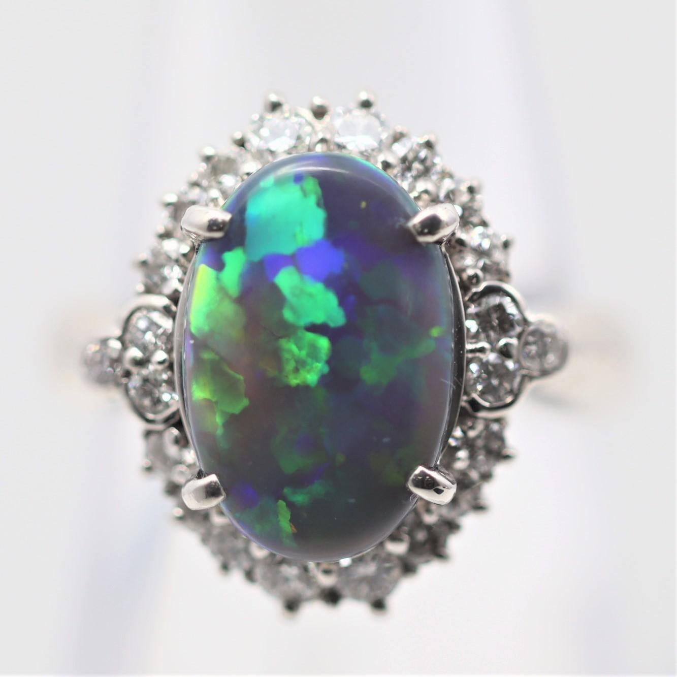 A classic black opal from the famous mines in Lightning Ridge, Australia. It weighs 2.07 carats and has fantastic play of color as bright vibrant flashes of green, blue, yellow, and orange can be seen across the stone. It is haloed by 0.64 carats of