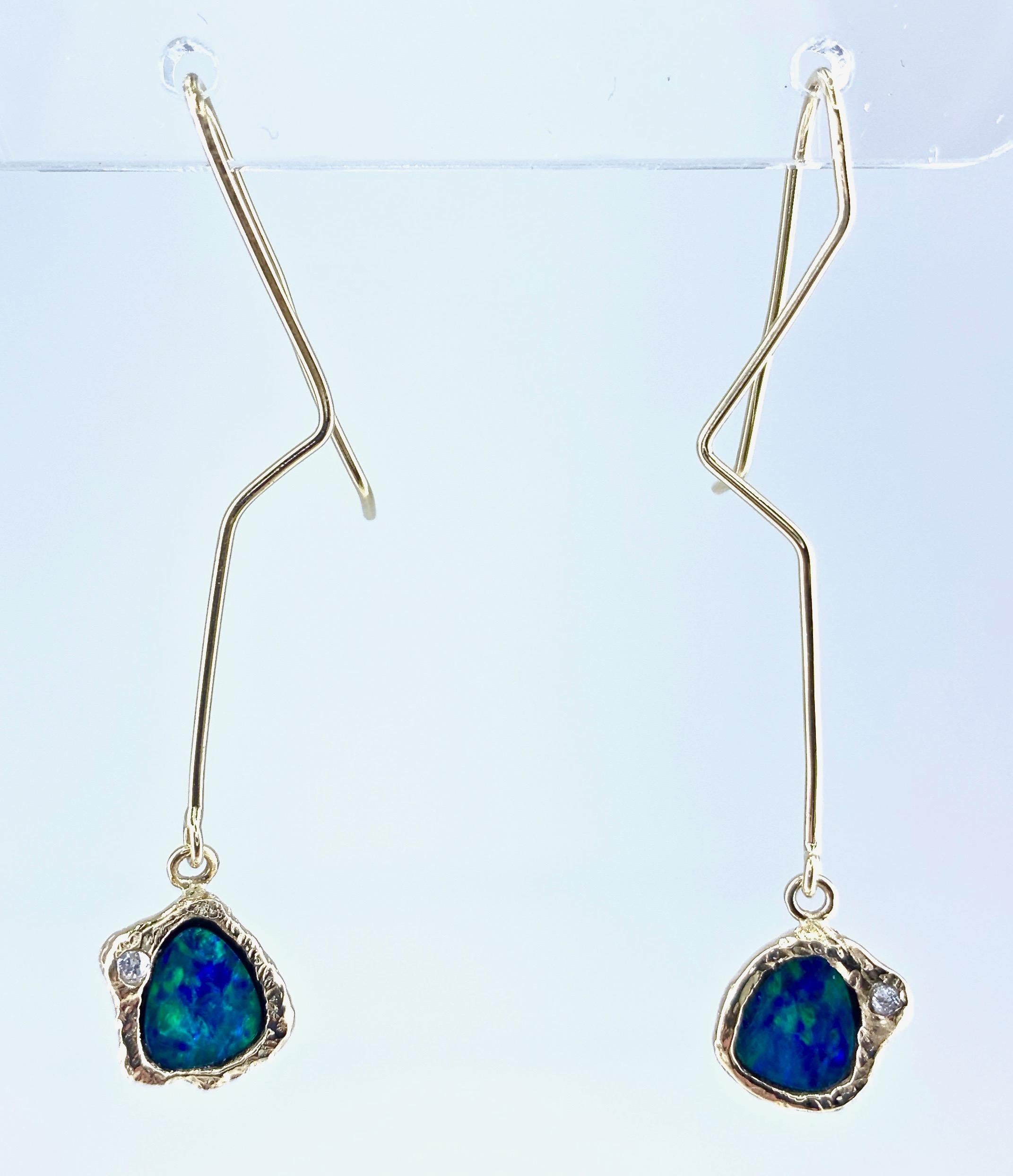 These clever, subtly mismatched, lightweight and fun-to-wear earrings were designed and handmade here in our shop by Eytan Brandes.  Each earring features  a fiery dark Australian black opal boulder opal framed in a hand-finished 18 karat yellow