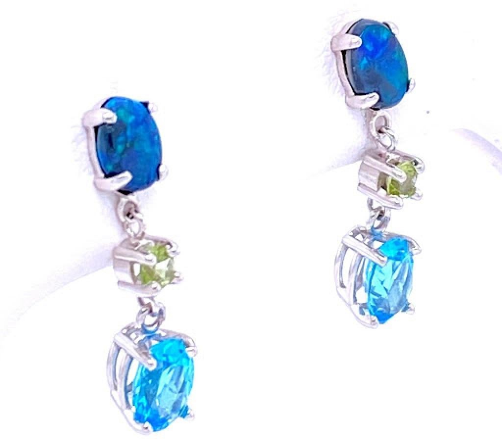 14 karat white gold earrings with 0.90 carat total weight of Australian black opal, 7 mm by 5 mm  blue topaz, and 2mm round peridot. The earrings have butterfly friction backs, and measures approximately 1