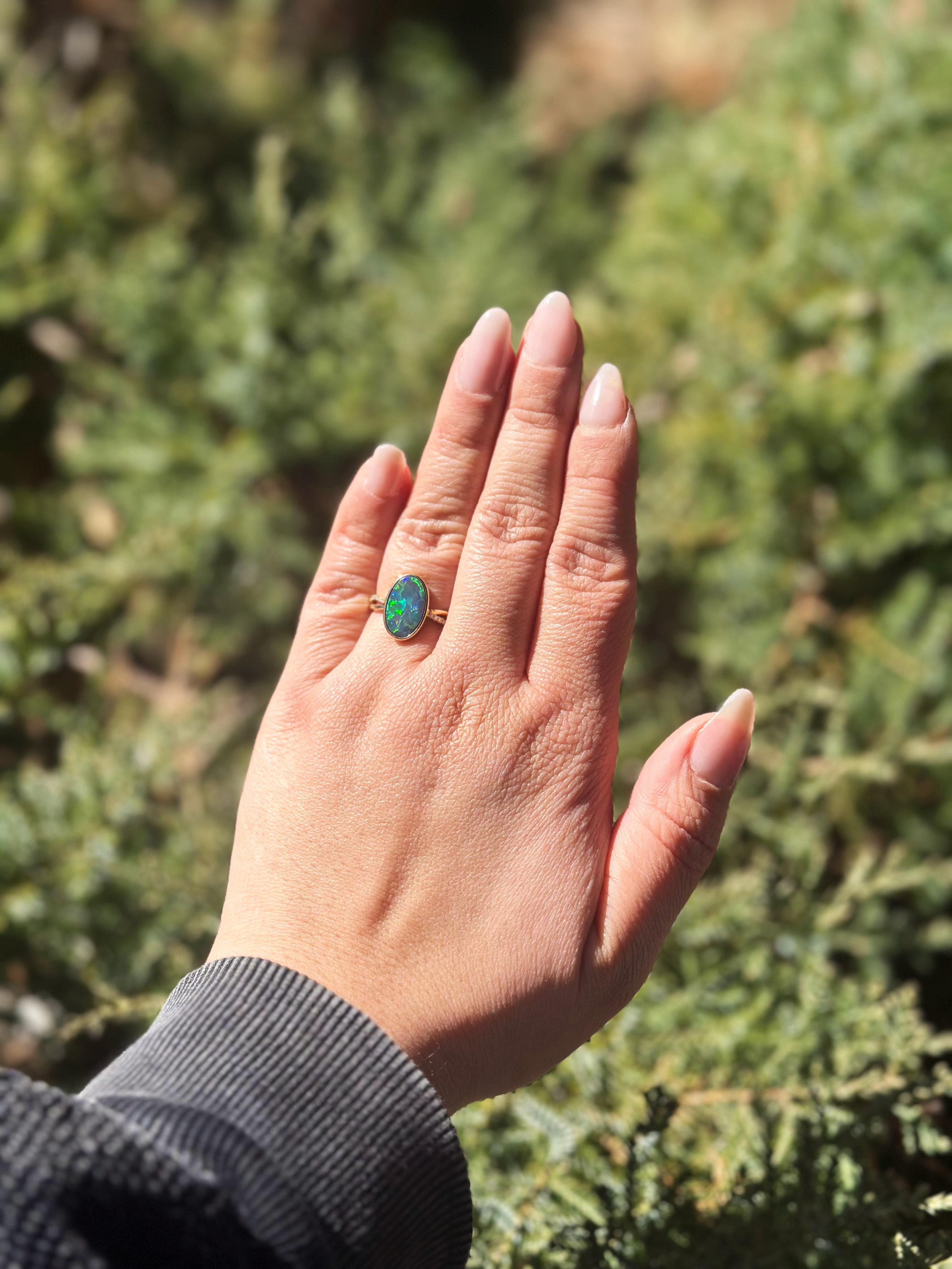 Oval Cut Australian Black Opal Ring with Diamonds made of 14 karat Yellow Gold For Sale