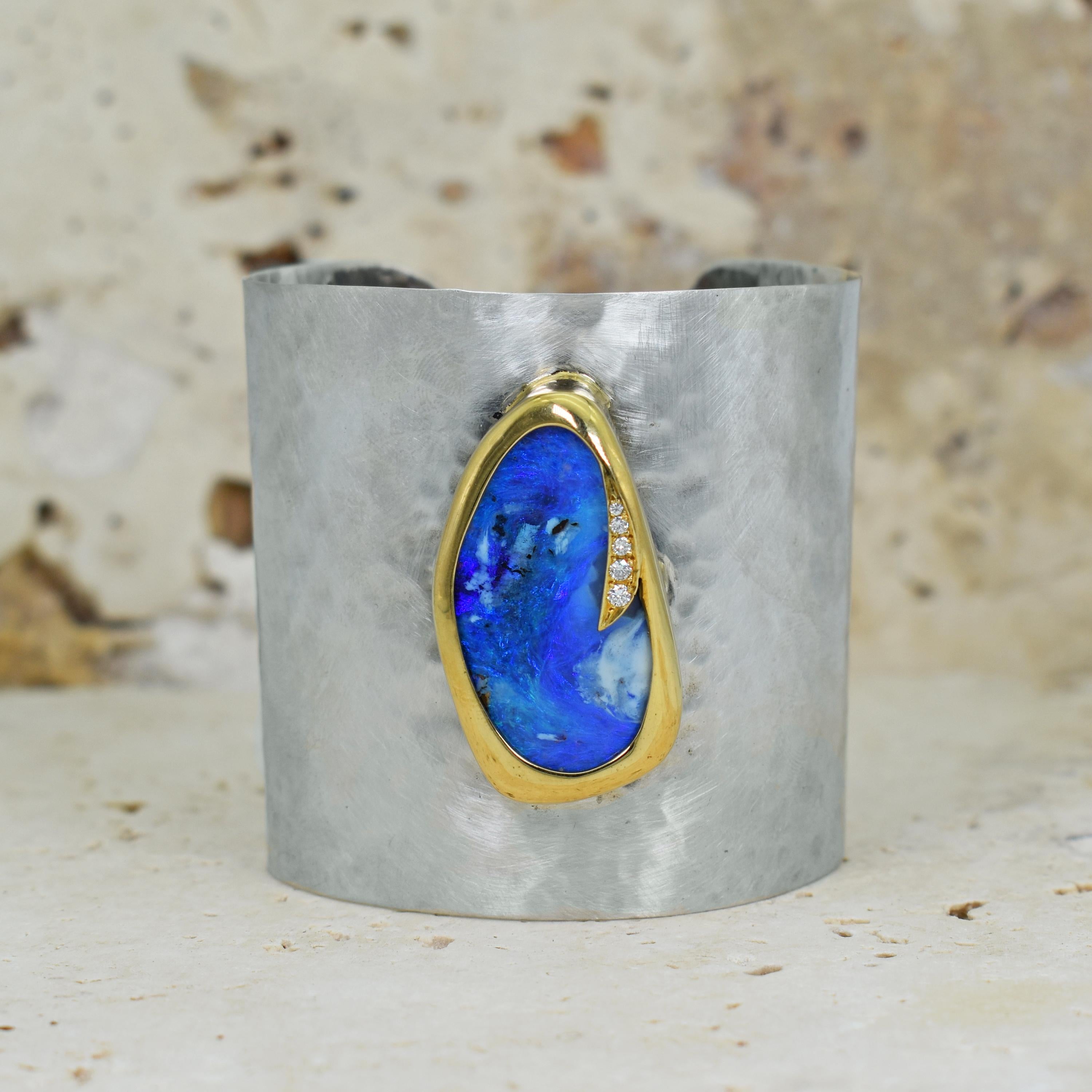 Gorgeous blue Australian Boulder Opal and accent white Diamonds (0.12 total carat, SI2, G-H) set in 18k yellow gold bezel on a hammered sterling silver cuff bracelet with a brushed, satin finish. Cuff bracelet is 2.25 inches wide.